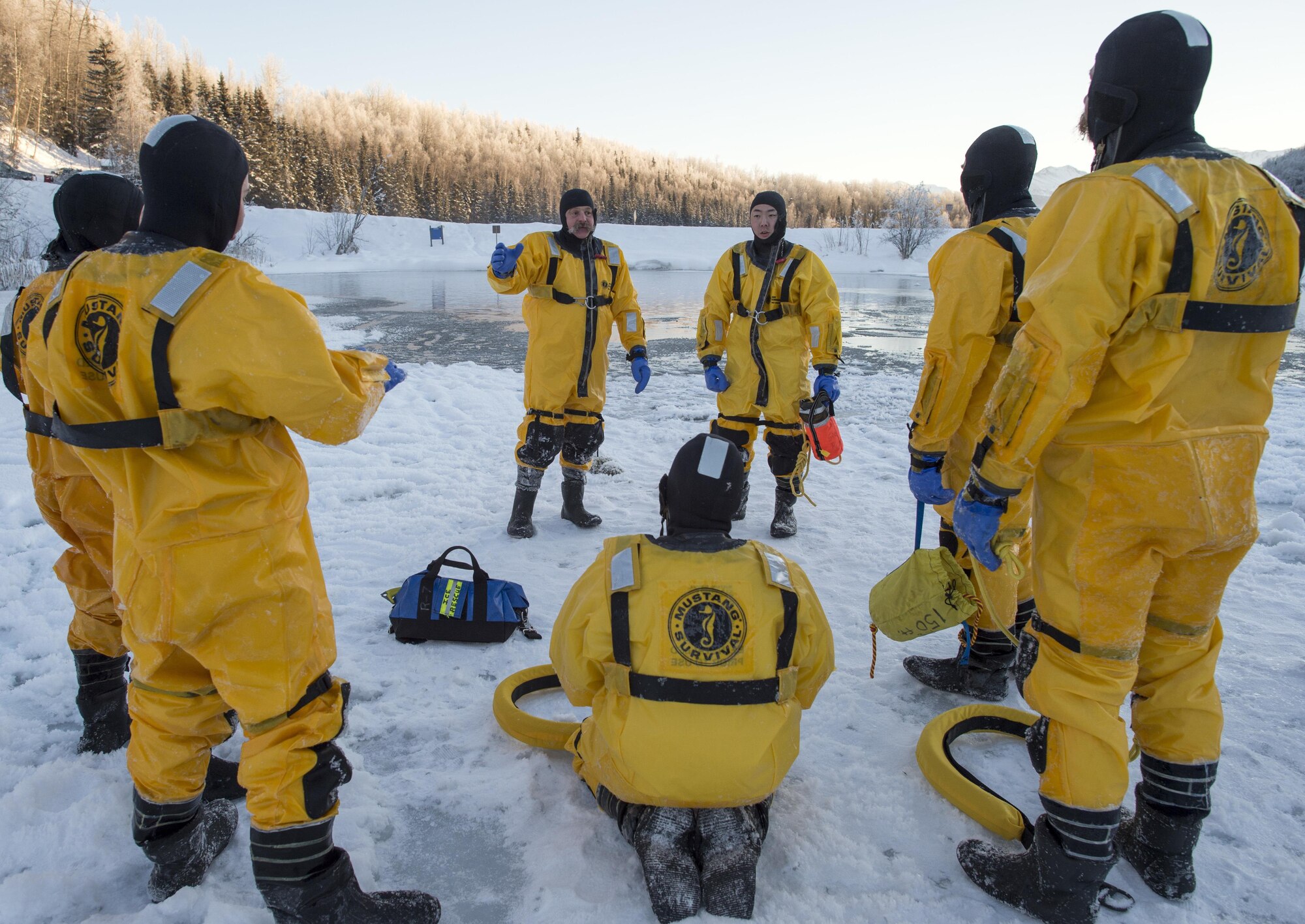 Kirk Gibbs, center, a fire captain assigned to the 673rd Civil Engineer Squadron, instructs junior fire fighters while conducting ice water rescue training at Joint Base Elmendorf-Richardson, Alaska Feb. 4, 2017. The training taught the JBER firefighters self-rescue techniques, victim recovery, and certified them as ice water rescue technicians. (U.S. Air Force photo/Alejandro Pena)