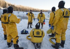 Kirk Gibbs, center, a fire captain assigned to the 673rd Civil Engineer Squadron, instructs junior fire fighters while conducting ice water rescue training at Joint Base Elmendorf-Richardson, Alaska Feb. 4, 2017. The training taught the JBER firefighters self-rescue techniques, victim recovery, and certified them as ice water rescue technicians. (U.S. Air Force photo/Alejandro Pena)