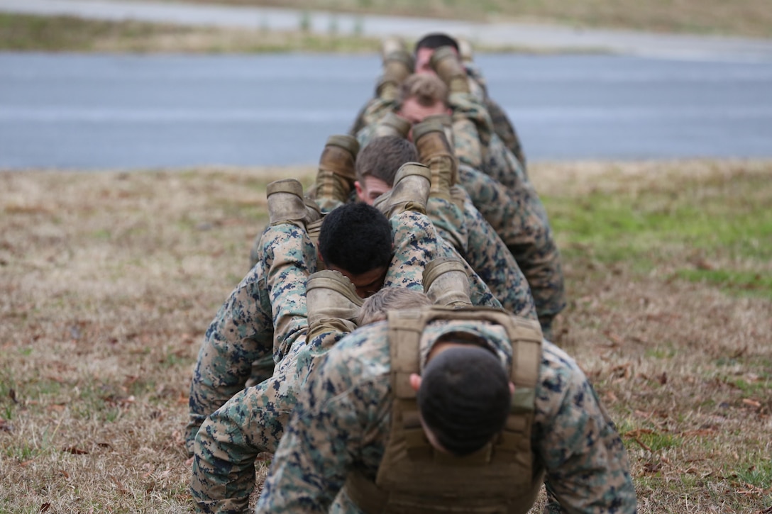 Marines execute squad push-ups during the culminating event of a Martial Arts Instructor course aboard Marine Corps Air Station Cherry Point, N.C., Feb. 3, 2017. The Marines completed 15 rigorous training days to become martial arts instructors. The course tested the Marines mentally and physically as they learned the ethos of the Marine Corps Martial Arts Program. More than 20 Marines from various units aboard the air station graduated the course. (U.S. Marine Corps photo by Lance Cpl. Cody Lemons/Released)