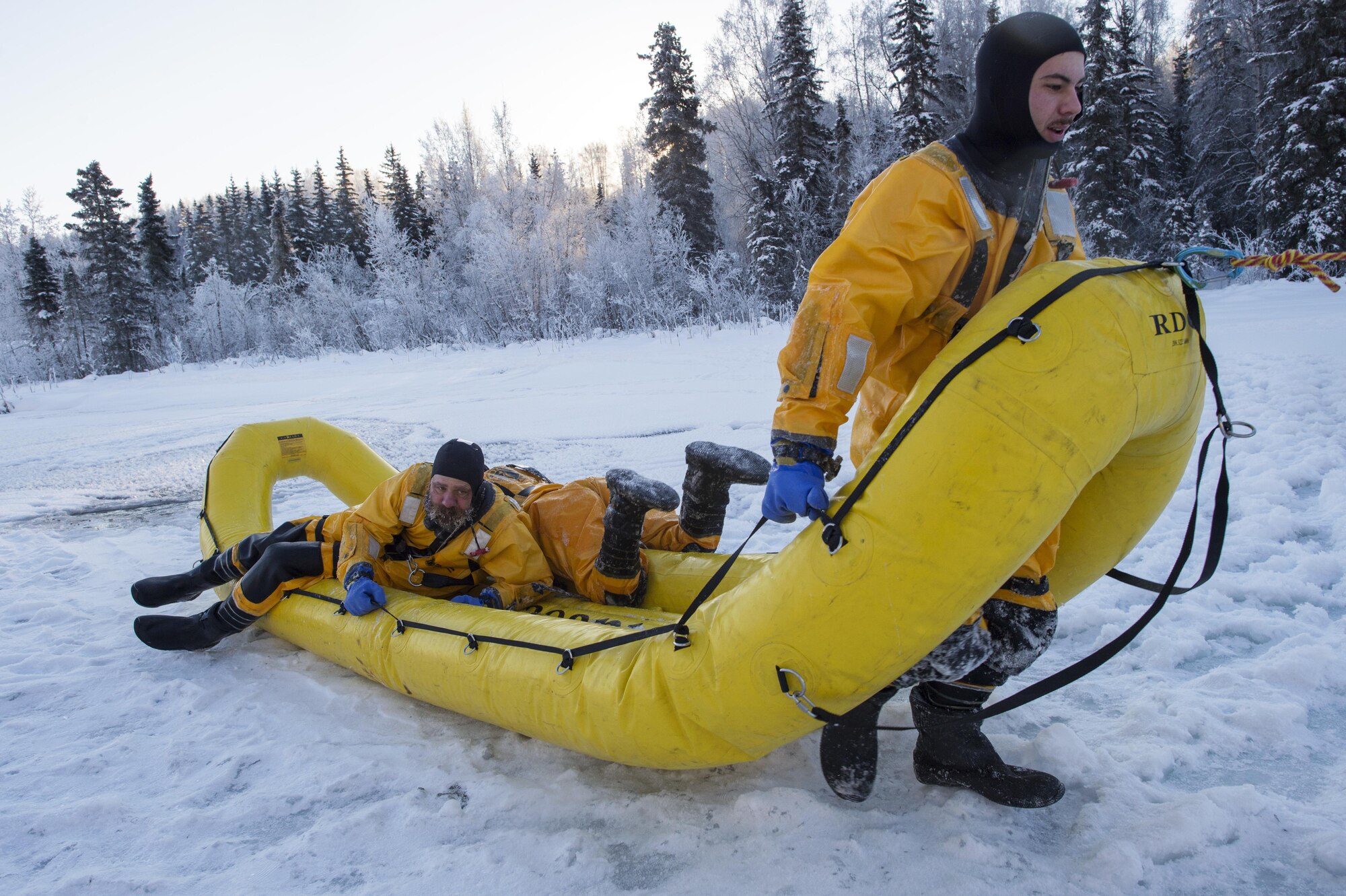 U.S. Air Force fire protection specialists assigned to the 673rd Civil Engineer Squadron, use an inflatable raft to recover a simulated cold water victim while conducting ice water rescue training at Joint Base Elmendorf-Richardson, Alaska Feb. 4, 2017. The training taught the JBER firefighters self-rescue techniques, victim recovery, and certified them as ice water rescue technicians. (U.S. Air Force photo/Alejandro Pena)