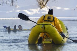 U.S. Air Force fire protection specialists, assigned to the 673rd Civil Engineer Squadron, use an inflatable raft to recover a simulated cold water victim while conducting ice water rescue training at Joint Base Elmendorf-Richardson, Alaska Feb. 4, 2017. The training taught the JBER firefighters self-rescue techniques, victim recovery, and certified them as ice water rescue technicians. (U.S. Air Force photo/Alejandro Pena)