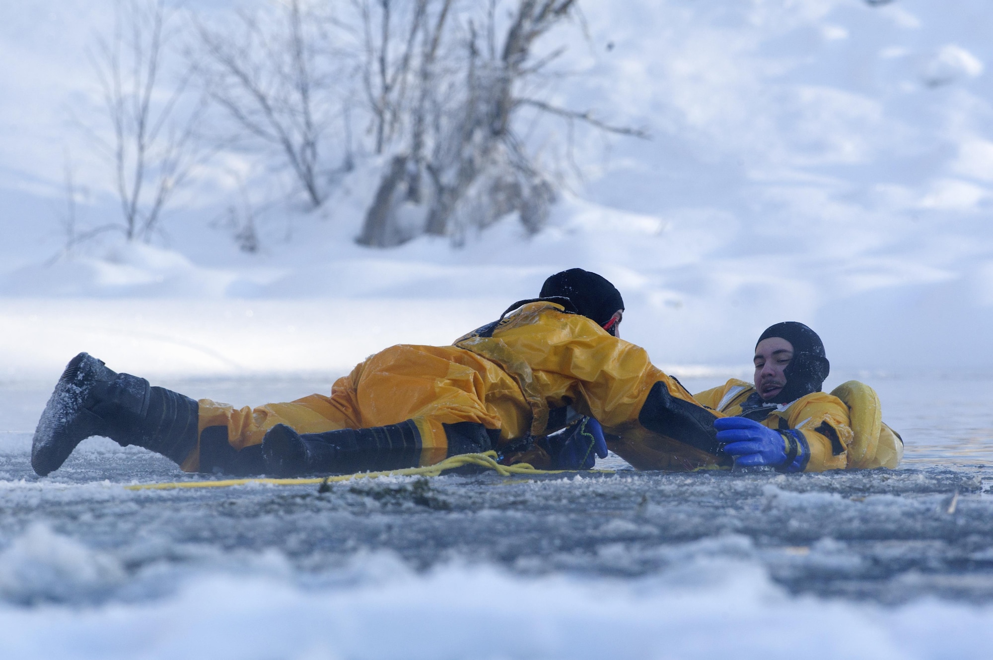 U.S. Air Force fire protection specialists Airmen 1st Class Joseph Humphrey, left and Tyler Parmelee, conduct ice water rescue training at Joint Base Elmendorf-Richardson, Alaska Feb. 4, 2017. The training taught the JBER firefighters self-rescue techniques, victim recovery, and certified them as ice water rescue technicians. Humphrey and Parmelee, natives of Ridgecrest, Calif., and Ashburn, Va., respectively, are assigned to the 673rd Civil Engineer Squadron. (U.S. Air Force photo/Alejandro Pena)