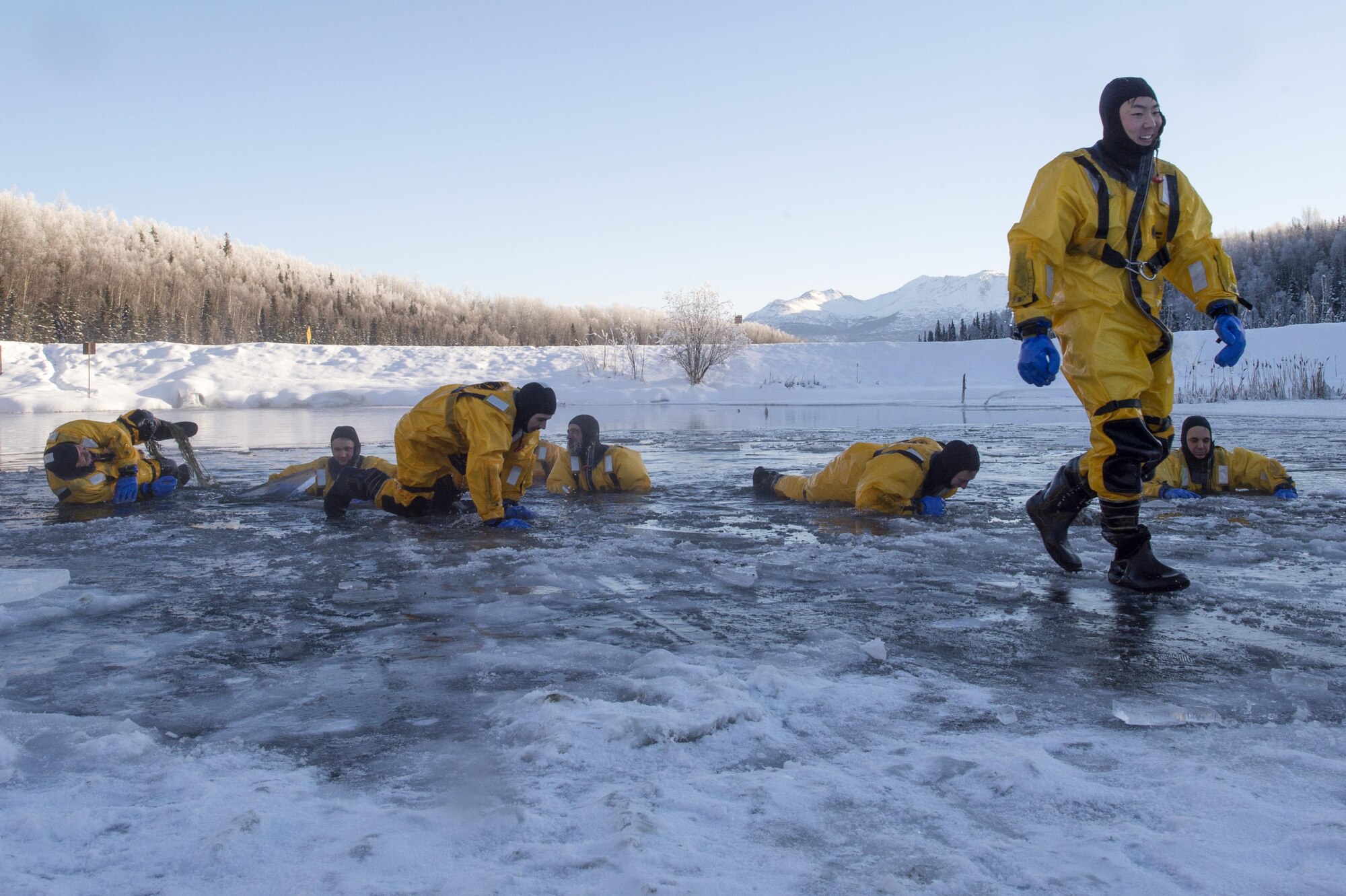 U.S. Air Force fire protection specialists, assigned to the 673rd Civil Engineer Squadron, pull themselves from a frigid lake after conducting ice water rescue training at Joint Base Elmendorf-Richardson, Alaska Feb. 4, 2017. The training taught the JBER firefighters self-rescue techniques, victim recovery, and certified them as ice water rescue technicians. (U.S. Air Force photo/Alejandro Pena)