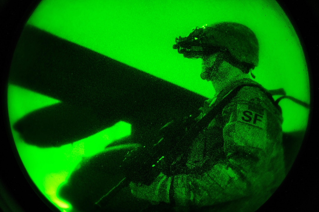As seen through a night vision device, Air Force Tech Sgt. Brady Mueller guards the perimeter of a C-130H Hercules aircraft in Iraq, Dec. 15, 2016. Muller is a security team member assigned to the 386th Expeditionary Security Forces Squadron. Air Force photo by Senior Airman Jordan Castelan