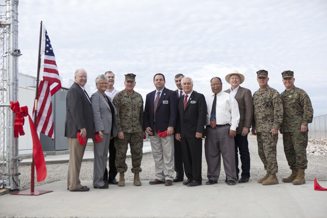 Representatives of the state of Arizona, city of Yuma, Arizona Public Service, and Marine Corps leaders celebrate the Marine Corps Air Staiton Yuma microgrid during a ribbon cutting ceremony at MCAS Yuma, Ariz., Dec 15, 2016. The microgrid project is a partnership between APS and MCAS Yuma that will provide enough backup power to cover 100 percent of current and projected base energy requirements, which far exceeds and may replace current backup capabilities. (U.S. Marine Corps photo by Cpl. Summer Romero/ Released)