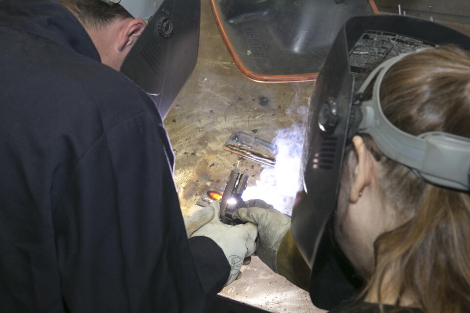 Tyler Ammerman, student, Twentynine Palms High School, practices stick welding with Leslie Hundley, welder, Exercise Support Division, during the Job Shadowing Event aboard Marine Corps Air Ground Combat Center, Twentynine Palms, Calif., Feb. 2, 2017. (U.S. Marine Corps photo by Cpl. Thomas Mudd)