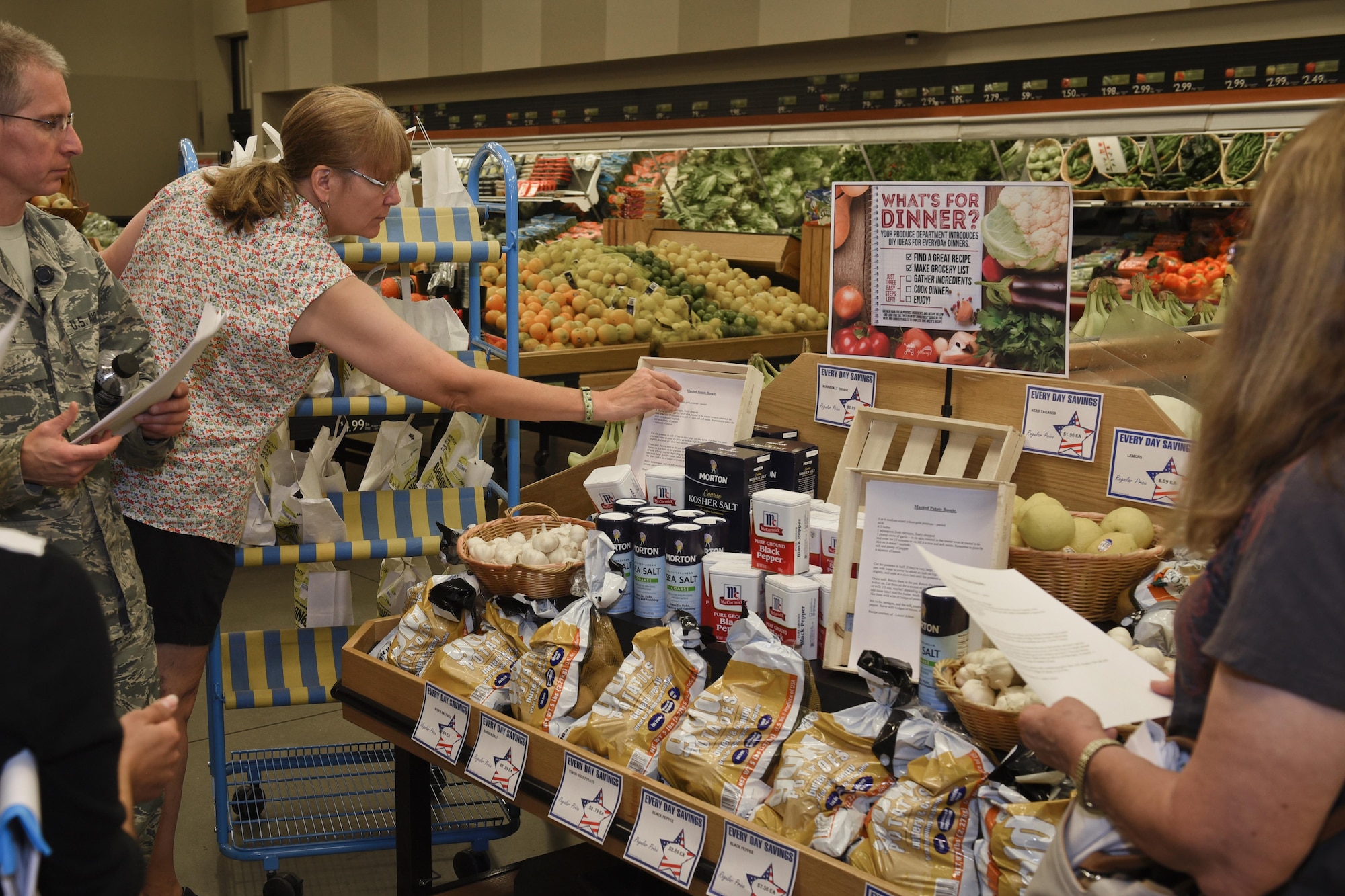 PETERSON AIR FORCE BASE, Colo. – Participants of the Fruit and Veggies – Eat More Tour view the “What’s for dinner” display at the commissary on Peterson Air Force Base, Colo., July 21, 2016. The display provides healthy recipes with every ingredient required in a central area so customers can easily find them. (U.S. Air Force photo by Senior Airman Rose Gudex)