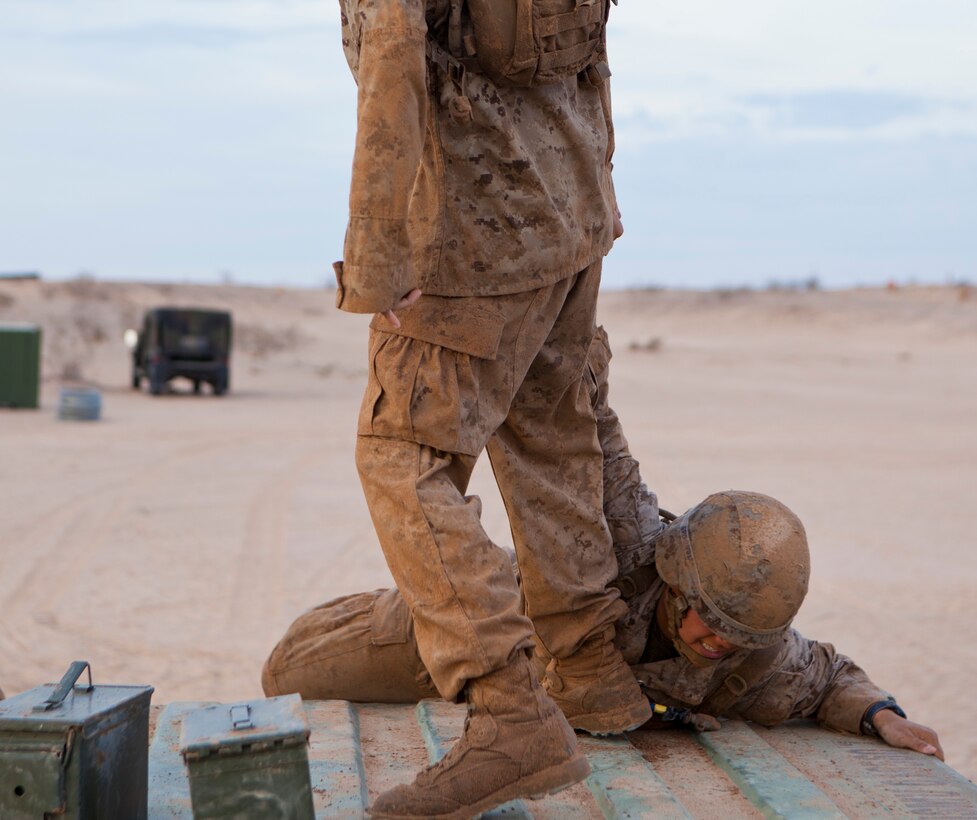 U.S. Marine Corps Cpl. Samantha Doyle with 8th Engineer Support Battalion gets help from a squad member up onto a container as part of a squad competition at Canon Air Defense Complex, Yuma, Ariz., Oct. 24, 2016. Squad competitions happen among every squadron throughout the Marine Corps to build camaraderie and foster good-spirited competition between the separate elements that make up the unit. (U.S. Marine Corps photo taken by Cpl. Summer Romero/ Released)