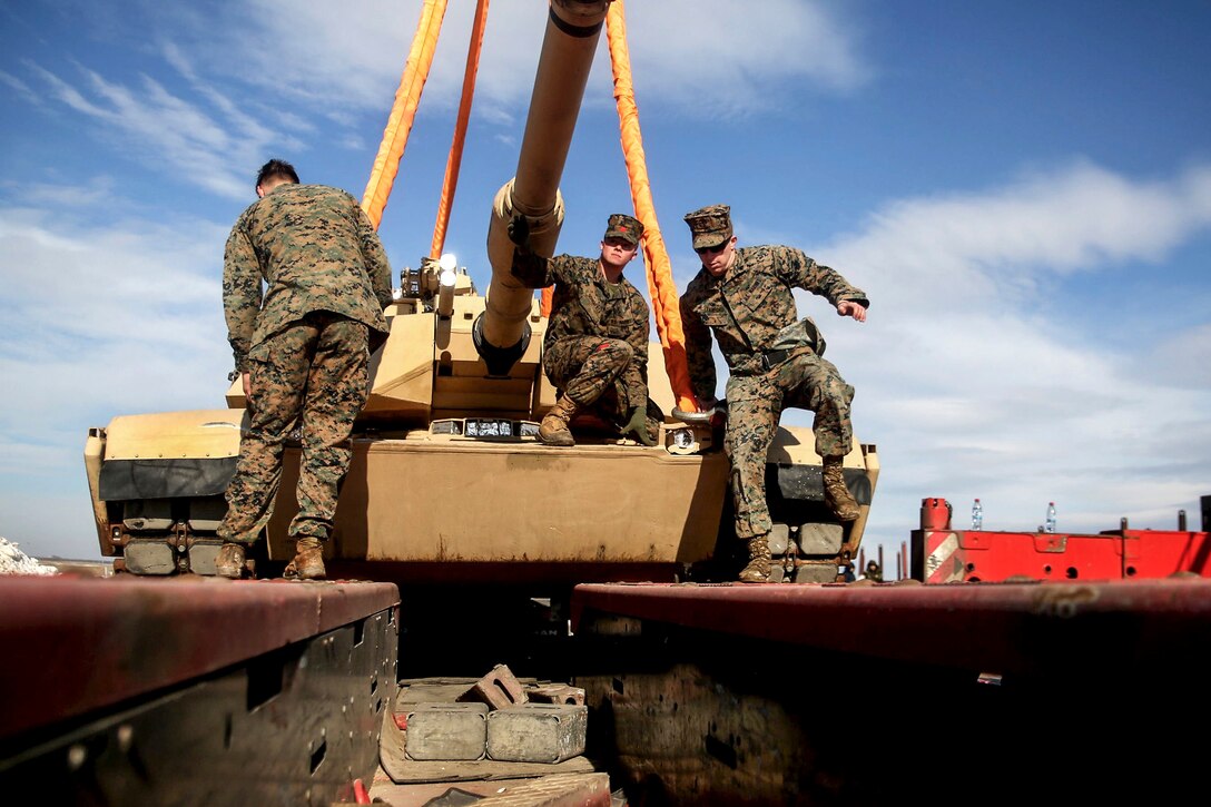Marines prepare to crane lift an M1 Abrams tank during railhead operations on Mihail Kogalniceanu Air Base, Romania, Feb. 4, 2017. The Marines, assigned to the Black Sea Rotational Force, trained to be able to transport vehicles to and from various locations. Marine Corps photo by Cpl. Sean J. Berry