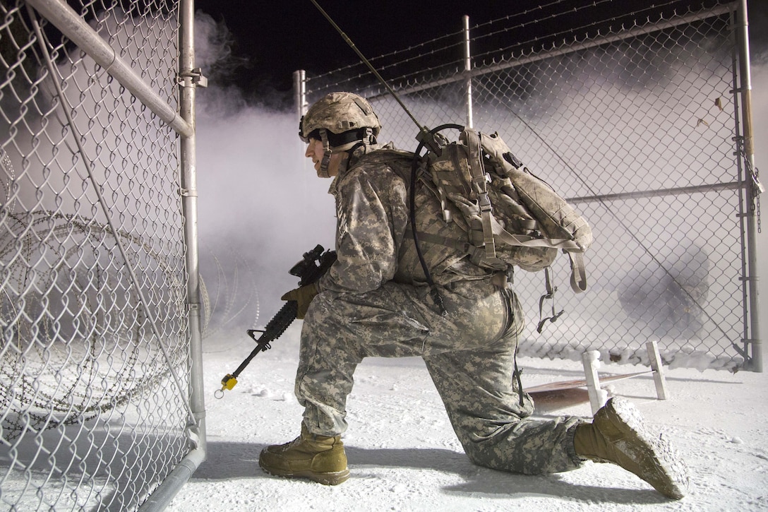 A soldier provides security near a concertina wire defensive perimeter during a simulated attack while participating in force protection sustainment training at Joint Base Elmendorf-Richardson, Alaska, Feb. 1, 2017. Air Force photo by Alejandro Pena