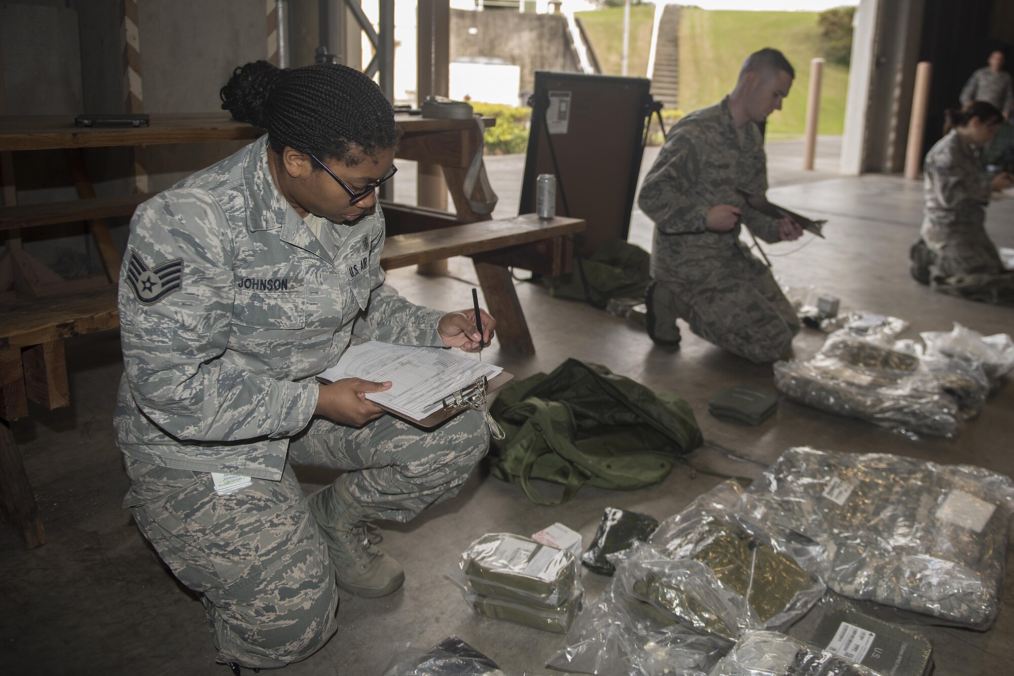 U.S. Air Force Airmen inventory their Mission-Oriented Protective Posture gear during an exercise Feb. 7, 2017, at Kadena Air Base, Japan. After quickly grabbing their MOPP gear, Airmen must make sure they have all essential pieces of equipment and sign for them. (U.S. Air Force photo by Airman 1st Class Corey M. Pettis/Released)