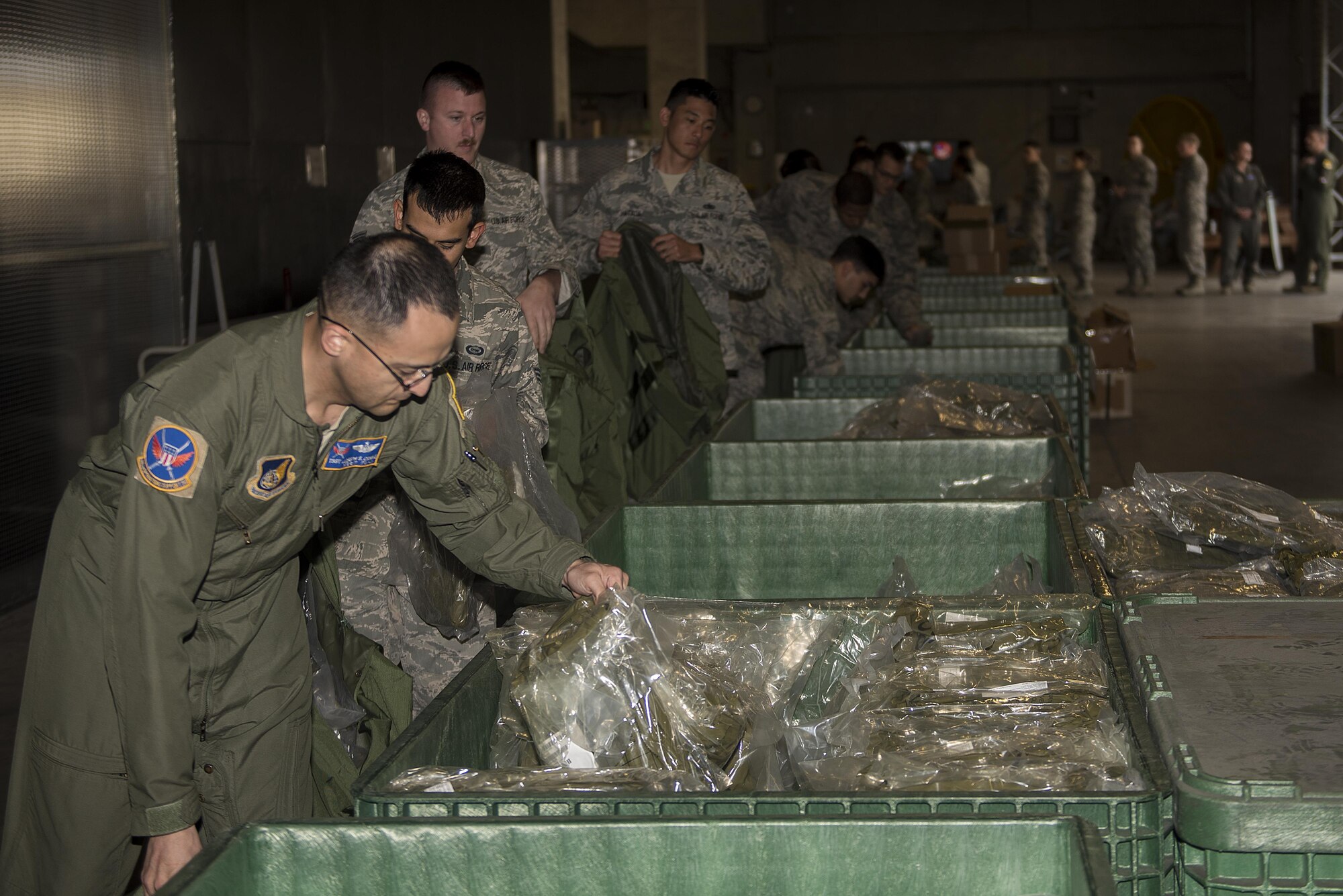 U.S. Air Force Airmen pick up Mission-Oriented Protective Posture gear during an exercise Feb. 7, 2017, at Kadena Air Base, Japan. In the event of an actual chemical attack, Airmen must be able to quickly and efficiently acquire all essential MOPP gear and equipment in order to complete mission objectives. (U.S. Air Force photo by Airman 1st Class Corey M. Pettis/Released)