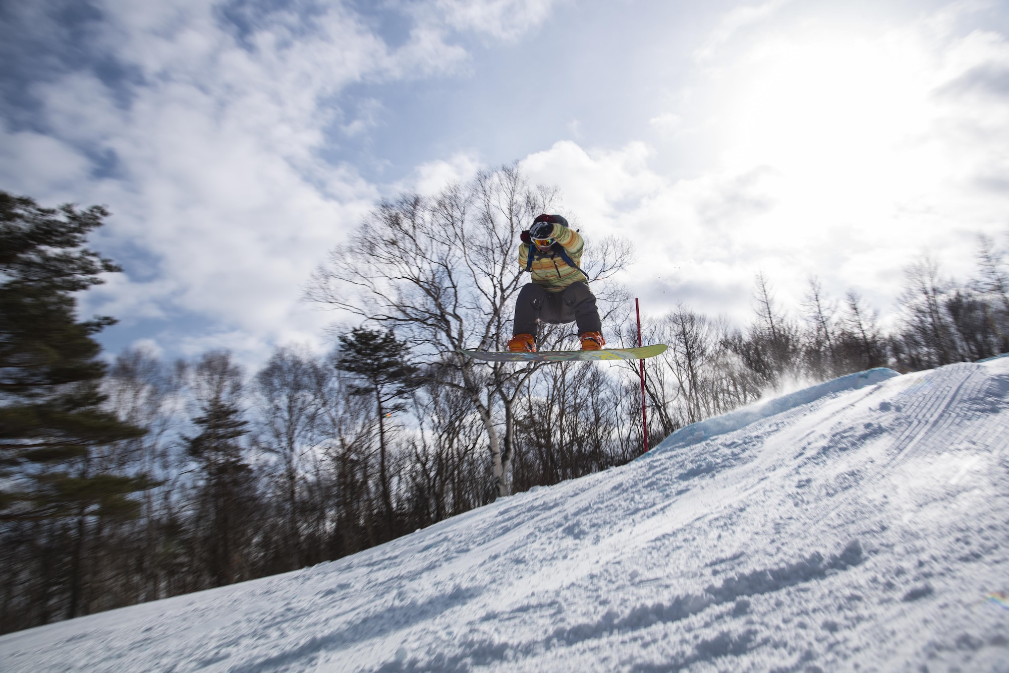 U.S. Air Force Airman 1st Class Alexander Crutchfield, a 35th Maintenance Squadron structures technician, makes a jump at a ski resort in Hachimantai, Japan, Jan. 29, 2017. Airmen from many shops had the opportunity to ski or snowboard to practice the four Air Force resiliency pillars including: physical, spiritual, mental and social domains. (U.S. Air Force photo by Airman 1st Class Sadie Colbert)