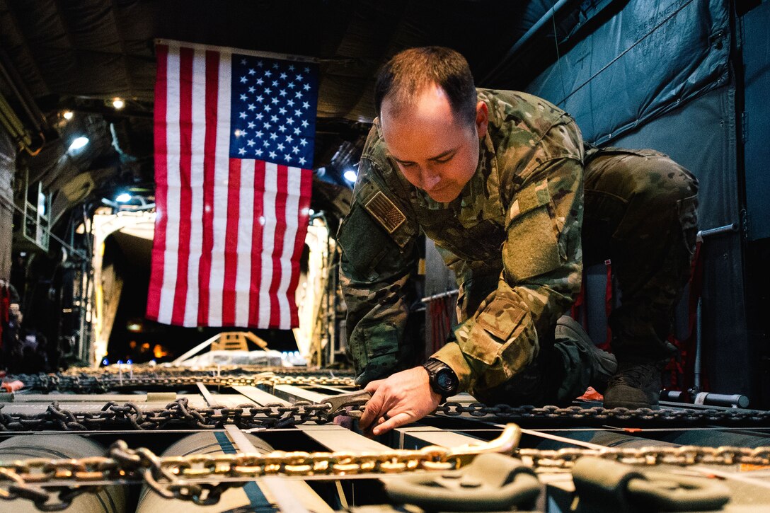 Air Force Senior Airman Creg Dubois straps down a load of cargo before takeoff inside a C-130H Hercules aircraft at Qayyarah Airfield West, Iraq, Feb. 3, 2017. Dubois is a loadmaster assigned to the Montana’s Air National Guard’s 737th Expeditionary Airlift Squadron. Air Force photo by Senior Airman Jordan Castelan 