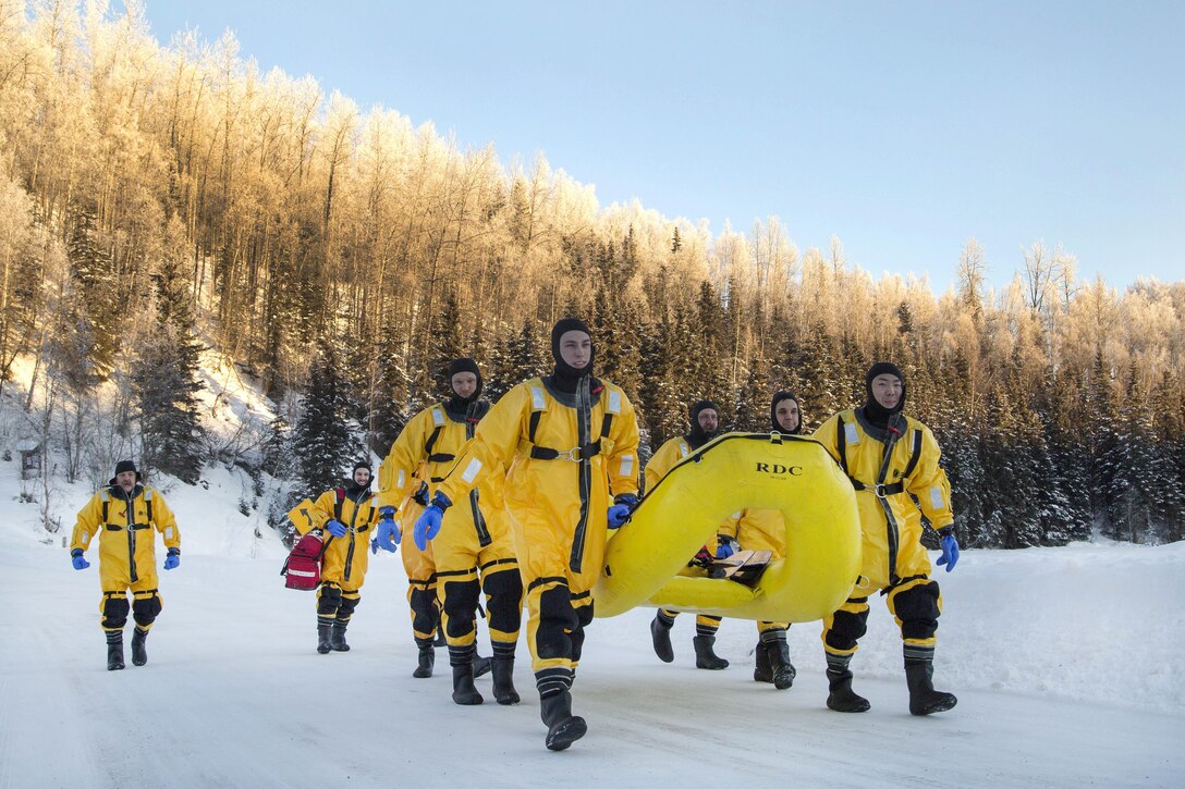 Air Force firefighters make their way to a frozen lake before participating in ice water rescue training at Joint Base Elmendorf-Richardson, Alaska, Feb. 4, 2017. The airmen are assigned to the 673rd Civil Engineer Squadron. The training, which taught self-rescue techniques and victim recovery, also certified the firefighters as ice water rescue technicians. Air Force photo by Alejandro Pena   