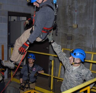 Staff Sgt. Joshua Spagnola of the New York National Guard’s 2nd Civil Support Team guides New York State Police Contaminated Crime Scene Emergency Response Team (CCSERT) member Investigator Brian Kenney  as he descends via a complex rope system during confined-space search-and-rescue training at the Watervliet Arsenal in Watervliet, N.Y. on Jan. 31, 2017.