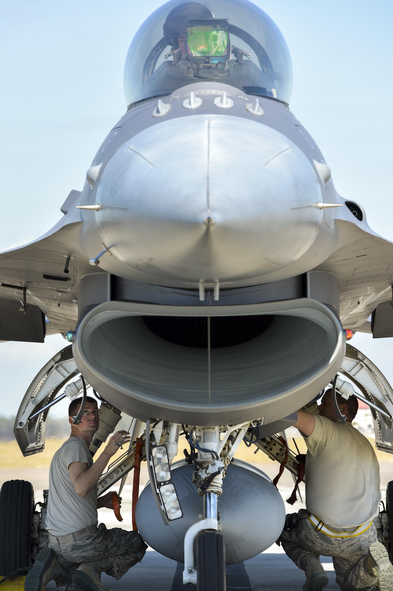 F-16 crew chiefs assigned to the 180th Fighter Wing, Ohio Air National Guard, inspect the hydraulic landing gear systems of an F-16 Fighting Falcon, inches away from the howling engine intake, just after the jet landed during a training exercise at MacDill Air Force Base in Tampa, Florida on Feb. 2, 2017. The 180th brought their F-16s and approximately 150 maintainers, pilots, and operations specialists to MacDill AFB for a two week training exercise which included basic fighter maneuvers against F-18 Hornets from the Canadian 425th Tactical Fighter Squadron, sharpening the combat capabilities of the OANG Airmen. (Air National Guard photo by Tech. Sgt. Nic Kuetemeyer)
