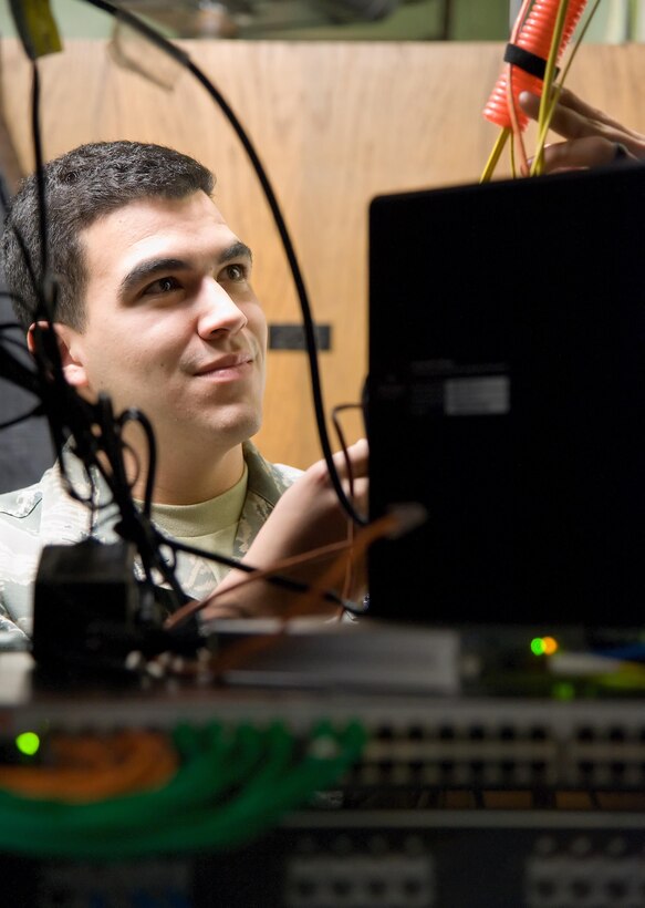 Airman 1st Class Jeffrey Bailey-Oqueli, 436th Communications Squadron cyber transport system technician, checks cables routed to newly installed communication switches Feb. 3, 2017, on Dover Air Force Base, Del. Bailey-Oqueli and contractors upgraded network hardware in building 201 as part of Dover's network modernization project. (U.S. Air Force photo by Roland Balik)
