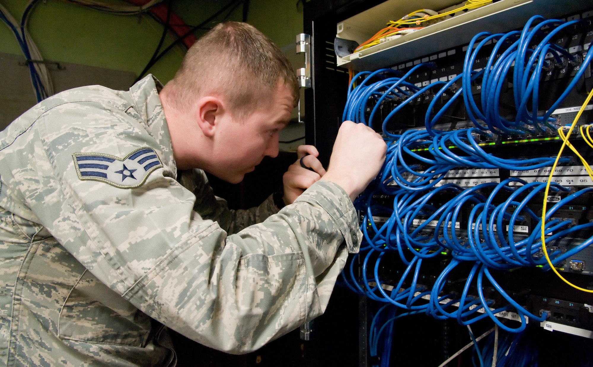 Senior Airman Gene Kellenberger, 436th Communications Squadron cyber operations technician, reconnects Cat 6 cables to a switch Feb. 3, 2017, on Dover Air Force Base, Del. Kellenberger and contractors upgraded network hardware in the second floor communication closet in building 201. (U.S. Air Force photo by Roland Balik)