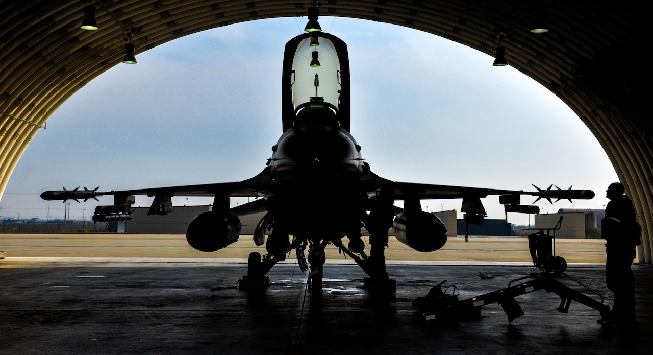 U.S. Air Force Lt. Col. Kevin Hicok, 51st Operation Support Squadron, Osan Air Base, pilot, performs his preflight checks on an F-16 Fighting Falcon under an outside hangar bay at Kunsan Air Base, Republic of Korea, Dec. 4, 2016. Aircrews here train alongside aircrews flying different types of aircraft, and this interoperability enables our members to be ready for many potential situations. (U.S. Air Force photo by Senior Airman Colville McFee/Released)
