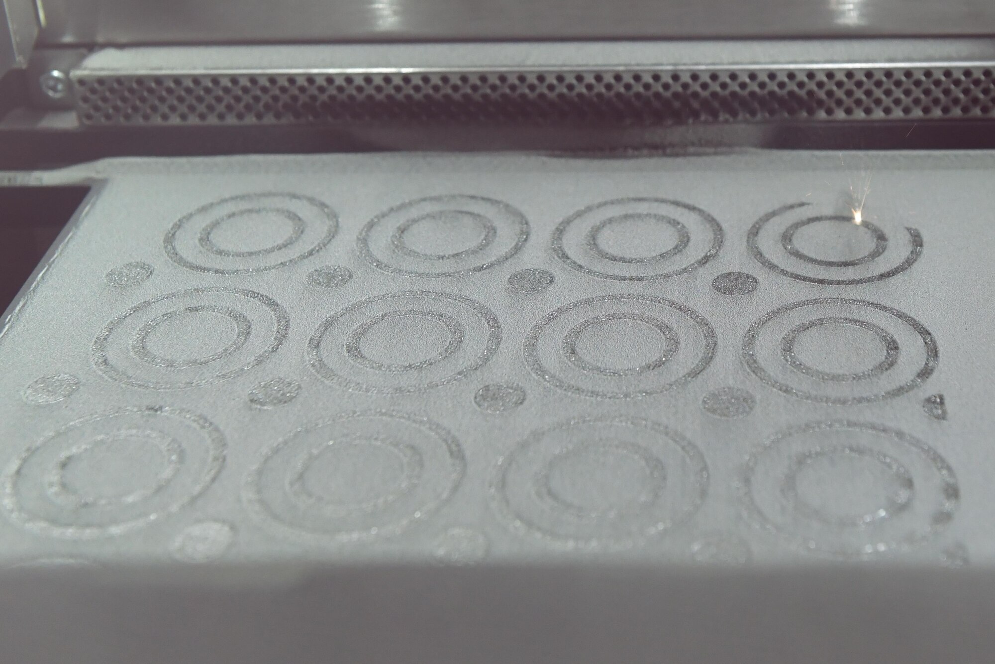 A 3-D printer at NAWCAD Lakehurst uses a laser to fuse a layer of metallic powder to create titanium parts at Joint Base McGuire-Dix-Lakehurst, New Jersey, Feb. 8, 2017. When the printer finishes a layer, new metal is added and the next layer up begins.  
