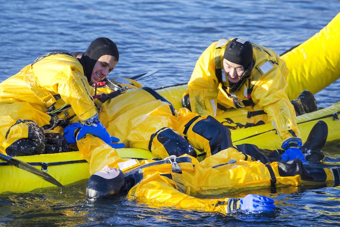 Jason Crandall, left and Air Force Senior Airman Joseph Pyun recover a simulated cold water victim while conducting ice water rescue training at Joint Base Elmendorf-Richardson, Alaska, Feb. 4, 2017. Pyun is a fire protection specialist assigned to the 673rd Civil Engineer Squadron. Air Force photo by Alejandro Pena