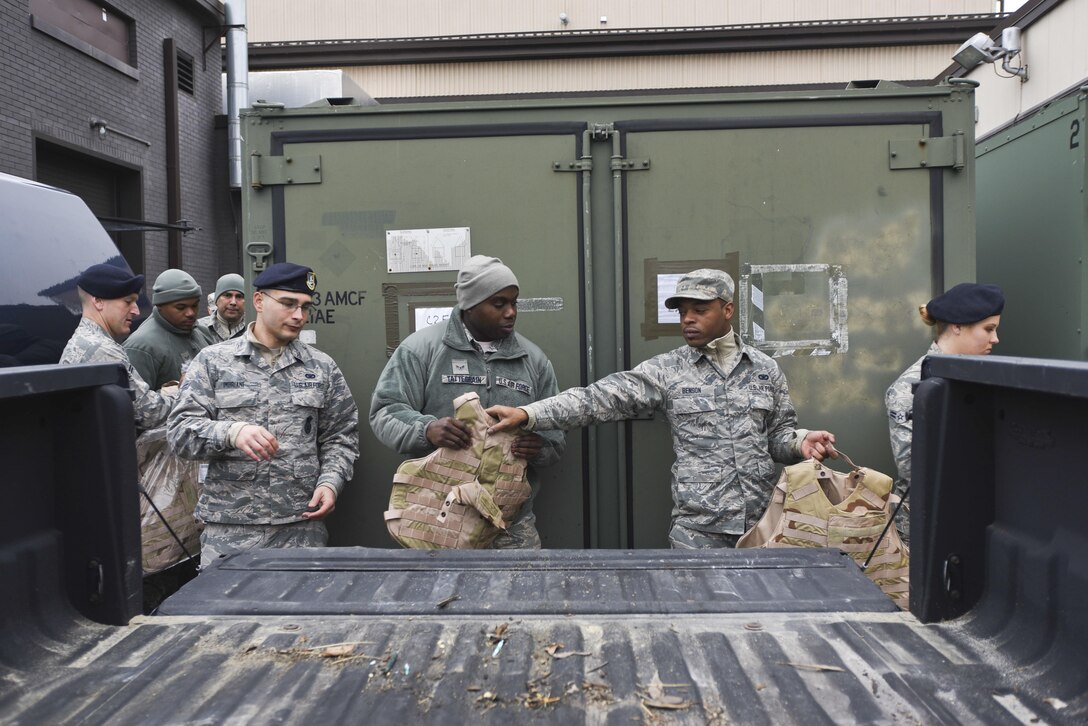 108th Security Forces Members pass equipment, bucket line style, out of a storage unit at the 108th Wing Joint Base McGuire-Dix-Lakehurst, N.J., Jan. 17, 2017. The Airmen move the equipment for counting, inspection, and distribution, in preparation of the Security Forces unit’s support of the 58th presidential inauguration. (U.S. Air National Guard photo by Staff Sgt. Ross A. Whitley/Released)