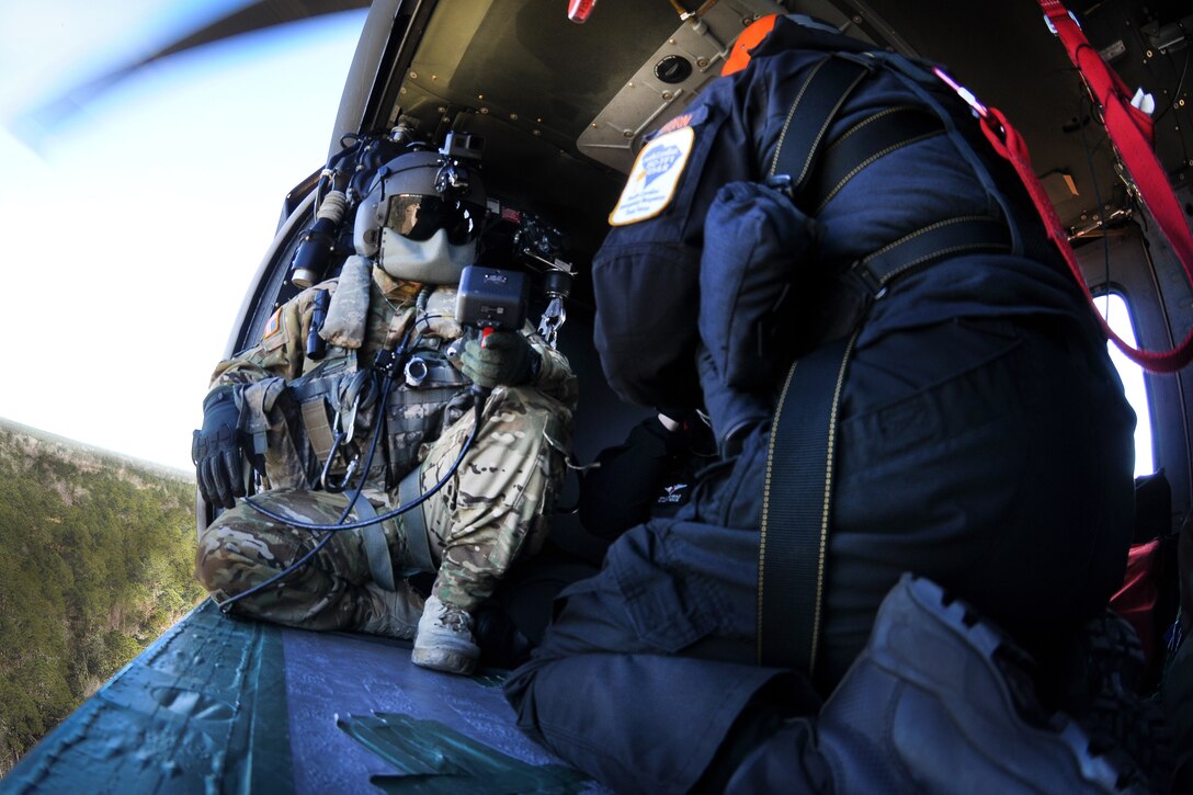 Army National Guard soldiers, fire department and emergency medical services rescuers from the South Carolina Helicopter Aquatic Rescue Team, and the South Carolina Urban Search and Rescue Task Force 1, fly in a UH-60 Black Hawk helicopter before participating in hoist training during Patriot South Exercise 2017, at the Gulfport and Port Bienville Industrial Complex, Mississippi, Jan. 31, 2017. Army National Guard photo by Staff Sgt. Roberto Di Giovine