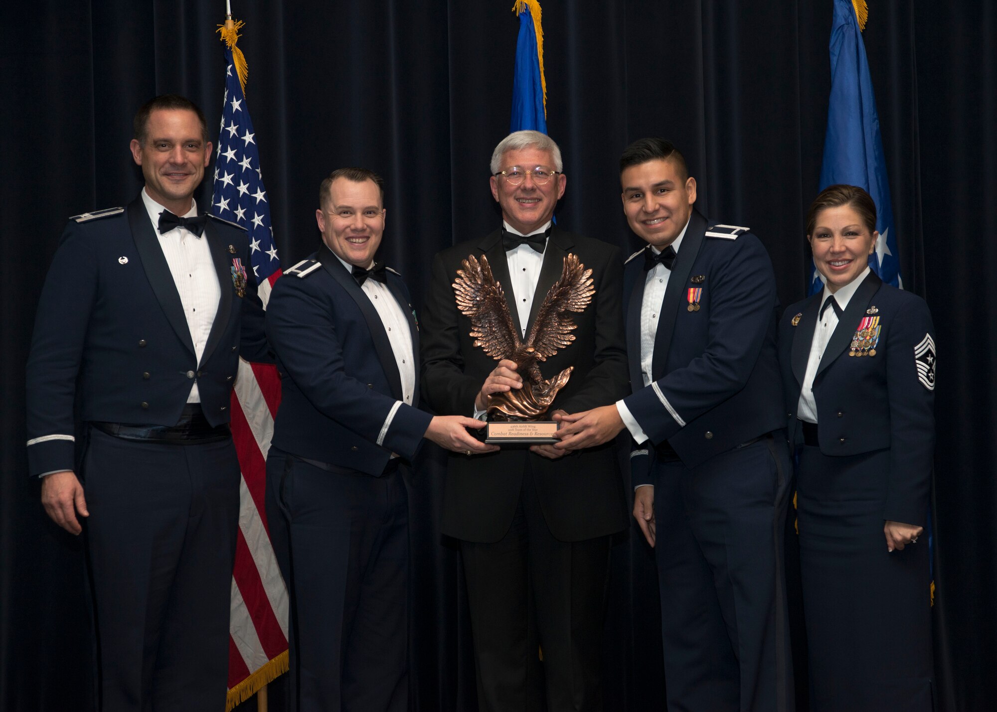 Col. Ethan C. Griffin, 436th Airlift Wing commander, Daniel Sitterly, guest speaker and Principal Deputy Assistant Secretary of the Air Force for Manpower and Reserve Affairs, and Chief Master Sgt. Sarah Sparks, 436th Airlift Wing command chief, present members of the 436th Aerial Port Squadron’s Combat Readiness and Resources Flight with the 436th AW Team of the Year trophy during the 2016 Annual Awards Ceremony Feb. 3, 2017, at the Rollins Center inside of Dover Downs, Dover, Del. The annual awards had 14 categories. (U.S. Air Force photo by Staff Sgt. Jared Duhon)