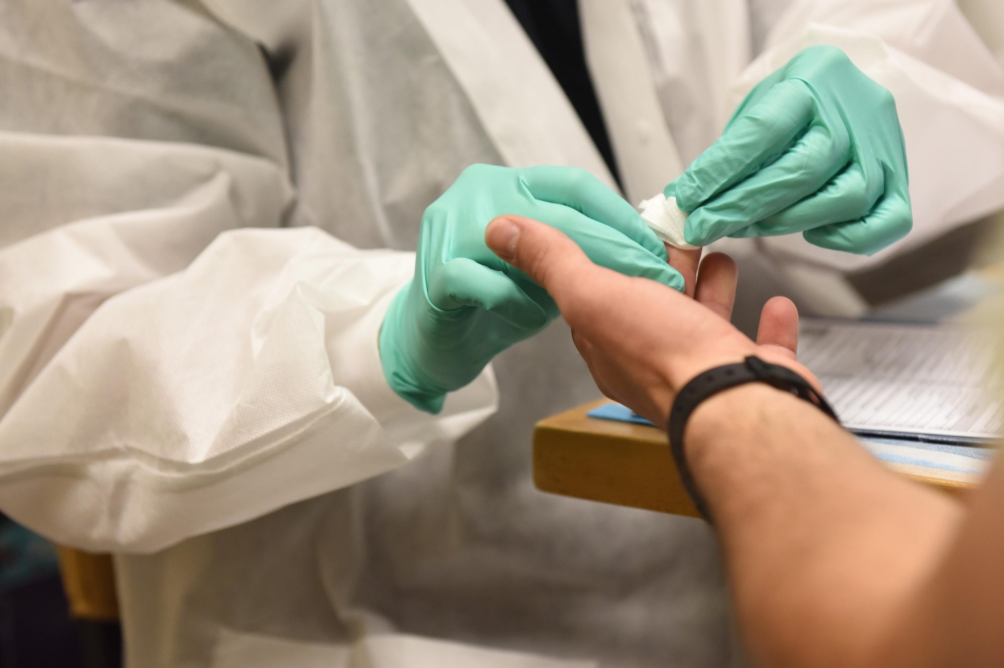 Karen Horn, 81st Diagnostic and Therapeutics Squadron medical laboratory technician, cleans the finger of Airman 1st Class Tré Moritz, 336th Training Squadron student, during a blood drive at Cody Hall Nov. 21, 2016, on Keesler Air Force Base, Miss. The Keesler Blood Donor Center is one of three Air Force blood donor centers and supports the Armed Services Blood Program by collecting blood for the Defense Department for use in deployed locations and military treatment facilities. (U.S. Air Force photo by Senior Airman Holly Mansfield)  