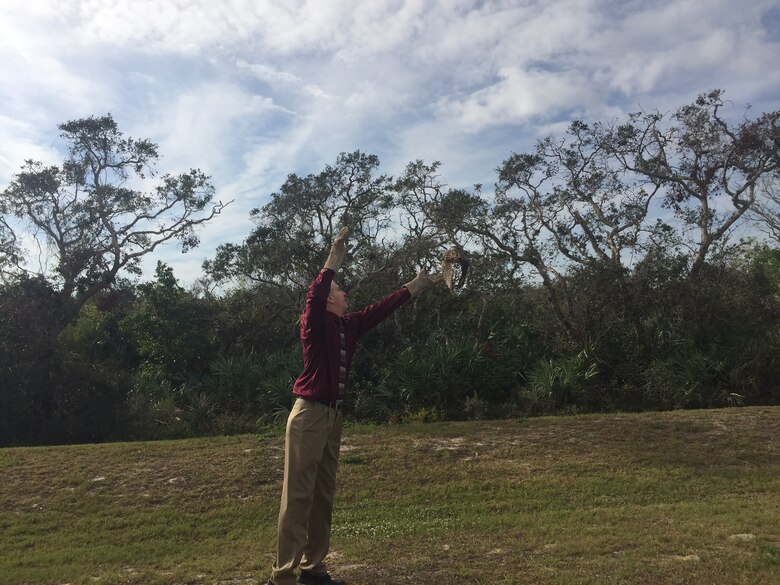 John Faulkner, 45th Civil Engineer Squadron deputy, helped with the release of the Juvenile red-shouldered hawk Jan. 26, 2017, at Cape Canaveral Air Force Station, Fla. The hawk was found near the Trident Basin Dec. 8, 2016, unable to fly and was then transported to the Florida Wildlife Hospital where they discovered he had two detached retinas.  The hawk was successfully rehabilitated and turned back over to the 45th Space Wing for release.  (Courtesy photo)