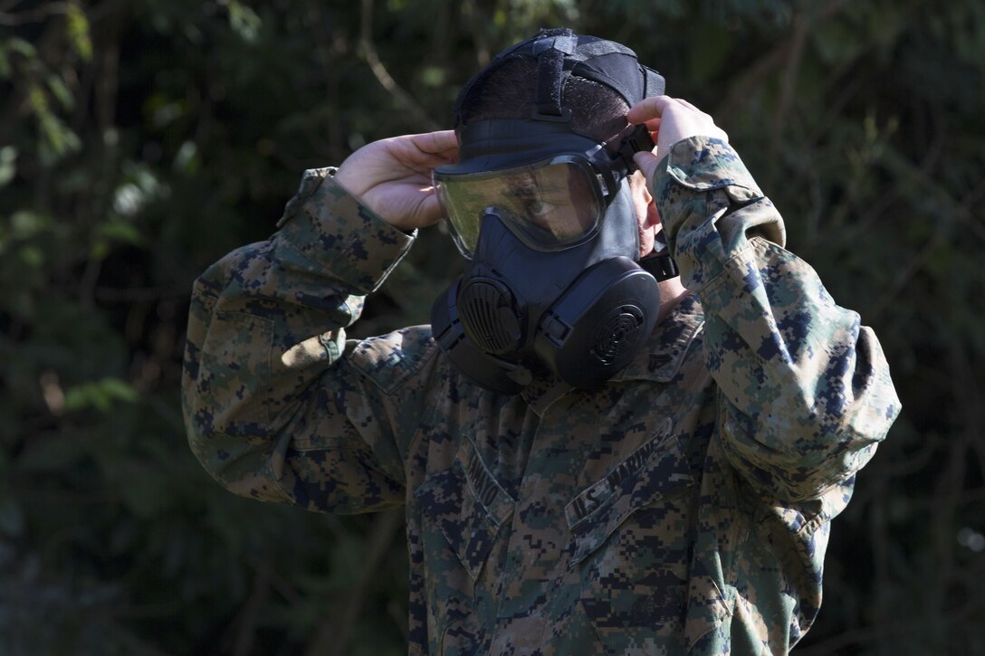 Marine Corps Cpl. Vhanhalin Tamayo adjusts his gas mask during an exercise at Marine Corps Air Station Futenma in Okinawa, Japan, Feb. 2. 2017. Marine Corps photo by Lance Cpl. Brooke A. Deiters
