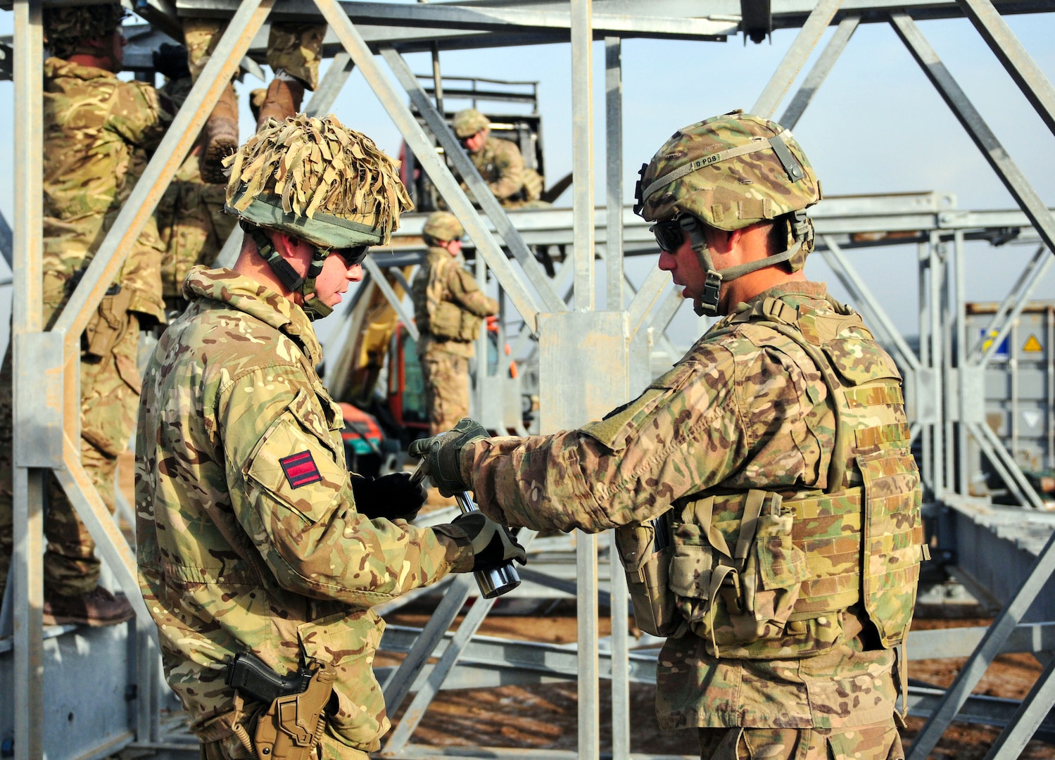 Soldiers from the 310th Multi-Role Bridge Company work alongside engineers from the British Army to dismantle an Acrow bridge they built together.  The Acrow bridge built helped hone the skills of U.S. and British engineers in preparation to train Iraqi Army bridge engineers at Camp Taji, Iraq, Jan. 31, 2017.  The 310th MRBC is assigned to the 153rd Engineer Battalion, 176th Engineer Brigade (Task Force Chaos).  (U.S. Army National Guard photo by Capt. Maria Mengrone/Released)