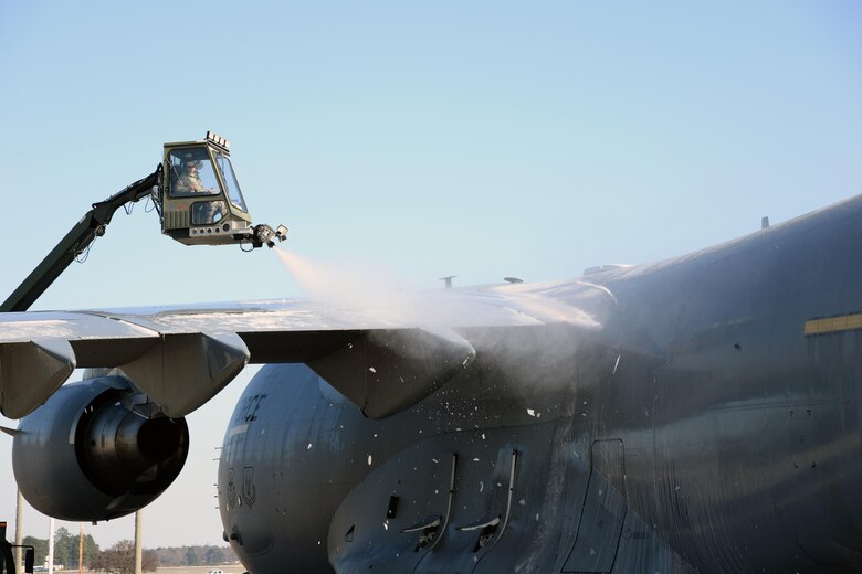 A member of the 43rd Air Mobility Squadron de-ices at C-17 Globemaster III on Pope Army Airfield's Green Ramp prior to loading cargo Jan. 8, 2017. The 43rd Air Mobility Operations Group handles all aircraft maintenance and aerial port operations for transient aircraft moving through Pope AAF. It is the only air mobiity operations group in the continental U.S. (U.S. Air Force photo by Master Sgt. Thomas J. Doscher)