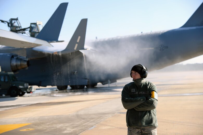 Airman 1st Class Kursten Davenport, 43rd Air Mobility Squadron ramp operator, stands by to load a C-17 Globemaster III on Pope Army Airfield's Green Ramp Jan. 8, 2017, while other 43rd AMS members de-ice a second C-17 behind her. An ice storm shut down most of North Carolina the previous day, delaying a Deployment Readiness Exercise. (U.S. Air Force photo by Master Sgt. Thomas J. Doscher/Released)
