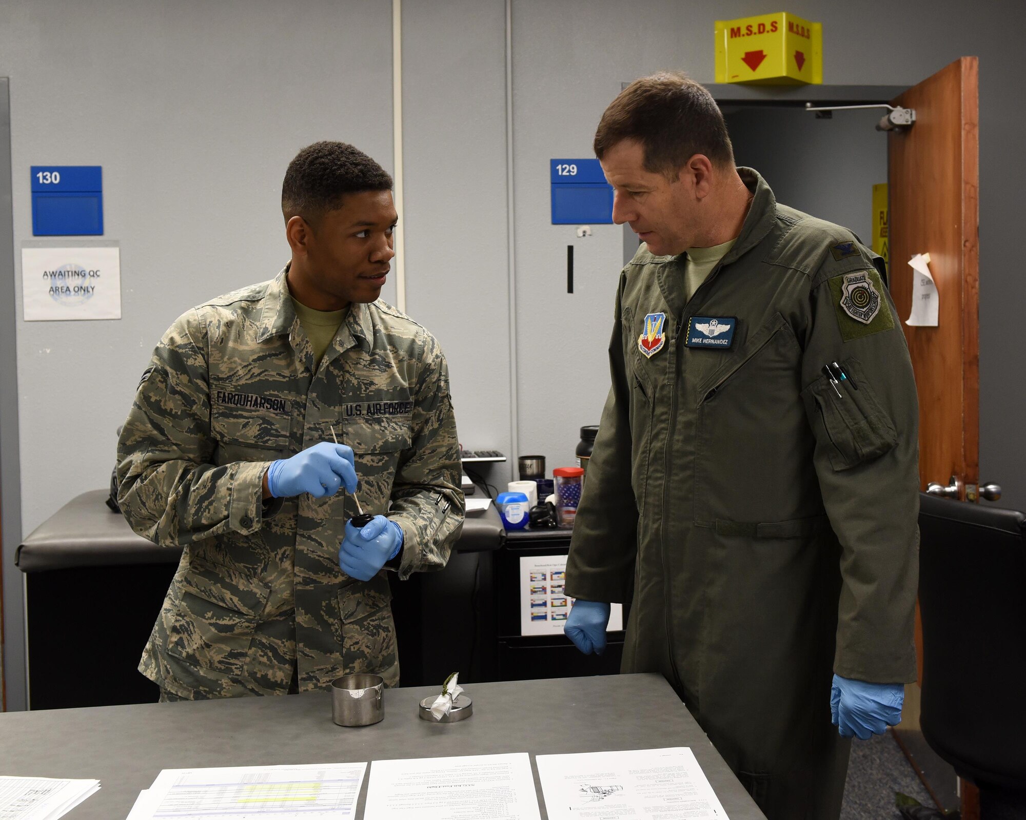 U.S. Air Force Airman 1st Class Donvin Farquharson, 325th Operations Support Group aircrew flight equipment technician, teaches Col. Michael Hernandez, 325th Fighter Wing commander, how to properly inspect and maintain aircrew flight equipment at Tyndall Air Force Base, Fla., Feb. 1, 2017. Farquharson was chosen to be shadowed by the base commander as a way for the commander to get in touch with Airmen and understand their daily jobs and the challenges they may face. (U.S. Air Force photo by Airman 1st Class Cody R. Miller/Released)