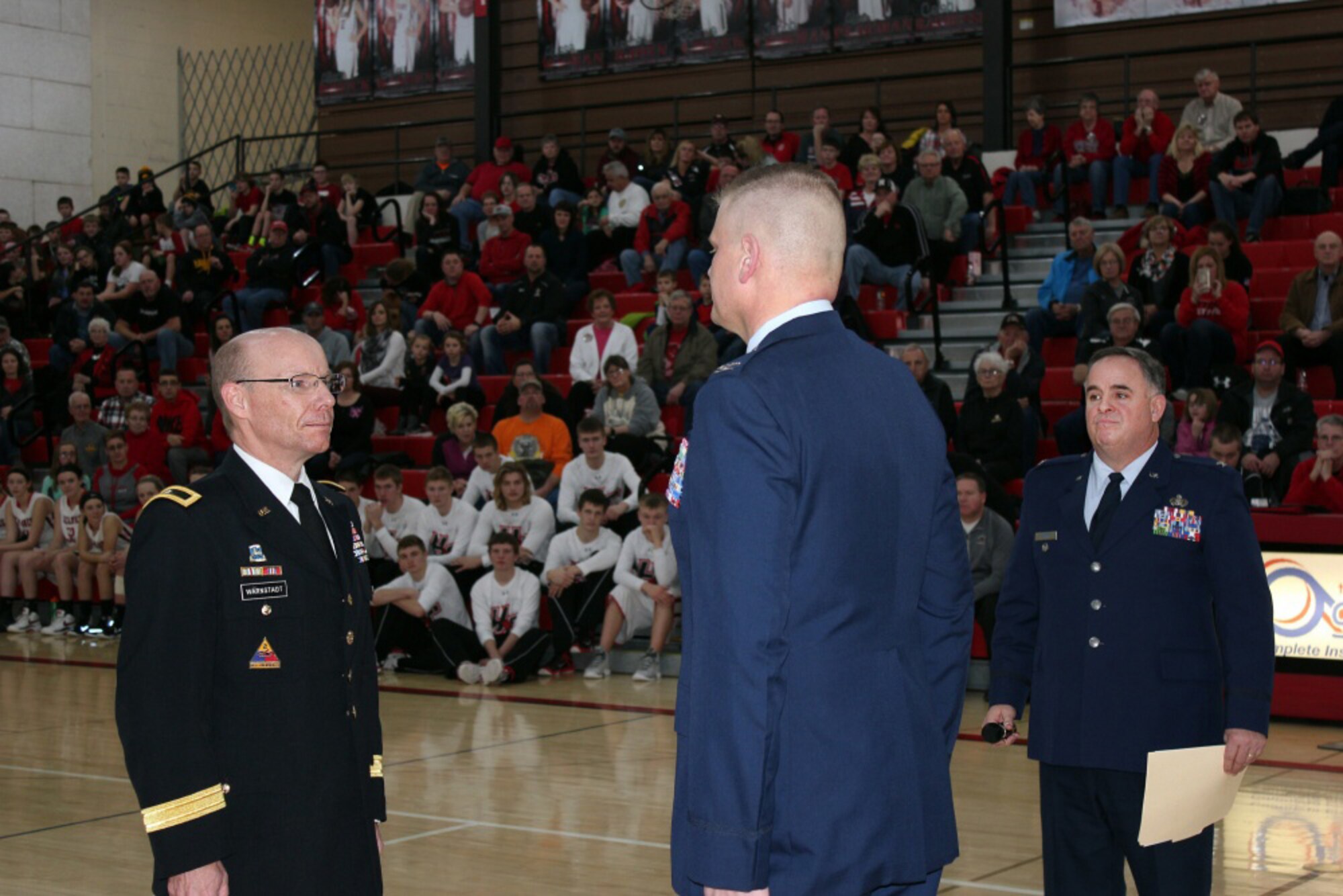 Newly-promoted Col. Justin Wagner, Iowa Air National Guard (center) stands at attention as his promotion orders to colonel are being read. Also present are Brig. Gen. Steve Warnstadt, Iowa Army National Guard (left) and Col. Joe Ascherl, Iowa Air National Guard. Wagner, the Harlan Community Schools superintendent, also serves as the Chief of Personnel for the Joint Planning Group, Iowa National Guard. (U.S. Army National Guard photo by Master Sgt. Duff E. McFadden)
