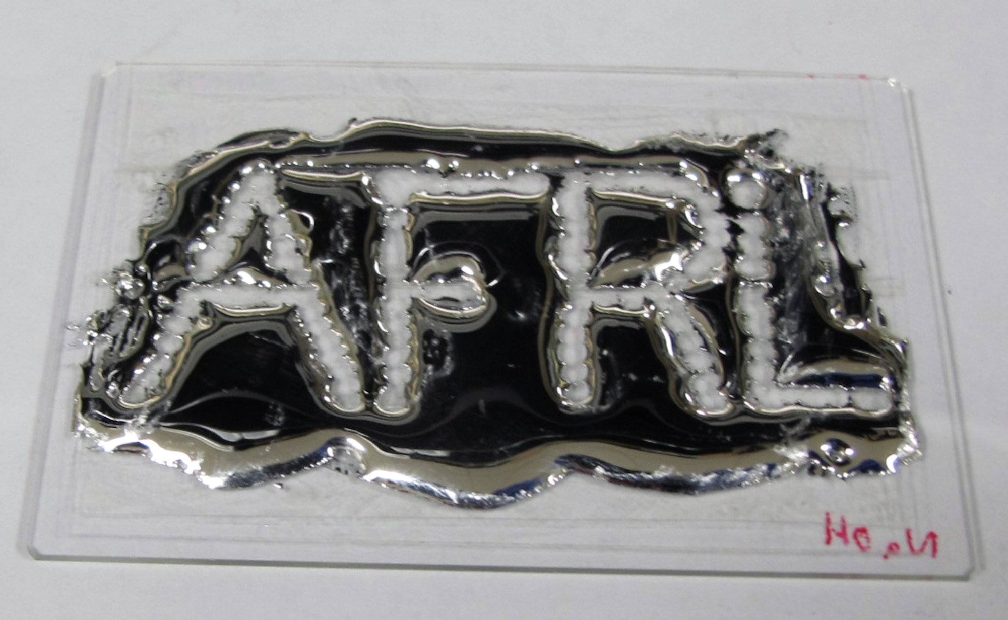 Scientists at the Air Force Research Laboratory are using the unique characteristic of liquid metal alloys to explore new ways to wire electronic systems. The unique properties of liquid metal alloys enable droplets to stack upon one another, unlike traditional liquids which flow into a singular shape. (Air Force courtesy photo)