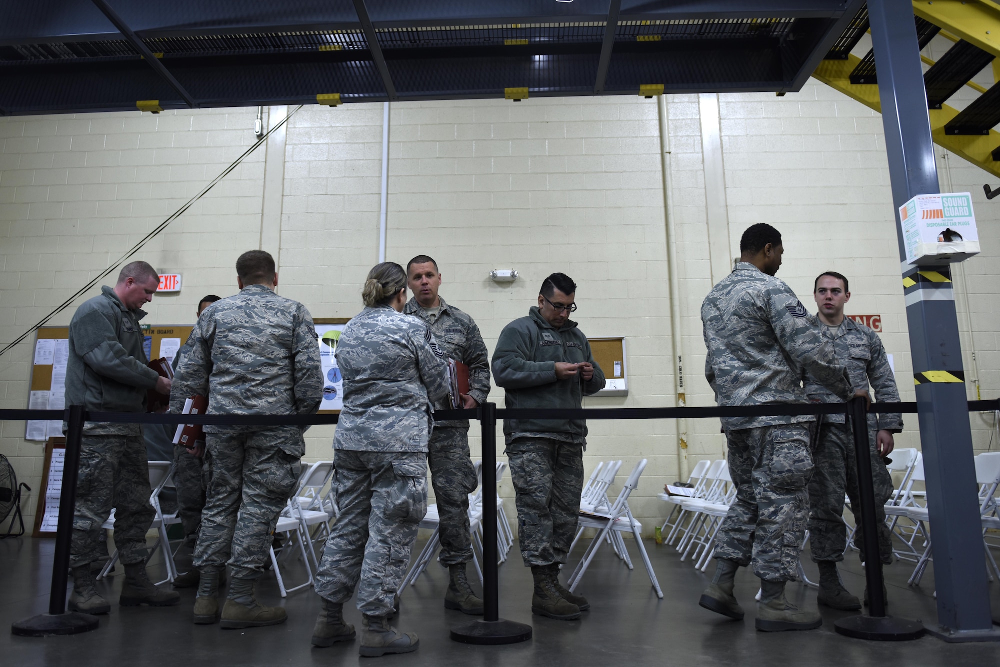 U.S. Air Force Tech. Sgt. Alejandro Armendariz (center), 145th Maintenance Squadron, clips together his dog tags while waiting in line during a deployment processing line held at the held at the North Carolina Air National Guard Base, Charlotte Douglas International Airport, Feb. 5, 2017. Armendariz is a crew chief and is deploying for the first time to maintain C-130 Hercules aircraft in support of Operation Freedom Sentinel to provide tactical airlift in the region.