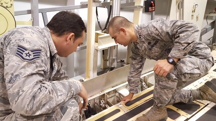 U.S. Air Force Capt. Sean Cox, (left), 437th Aircraft Maintenance Unit officer in charge, and Staff Sgt. Dustin Wineinger, (right), 373rd Training Squadron, Detachment 5, aeronautical repair instructor, inspect a C-17 Globemaster III cargo rail trainer assembly. Cox  was part of a 4-man team that received the Top Wing award upon graduation from the Advanced Sortie Production Course Dec. 7, 2016. 