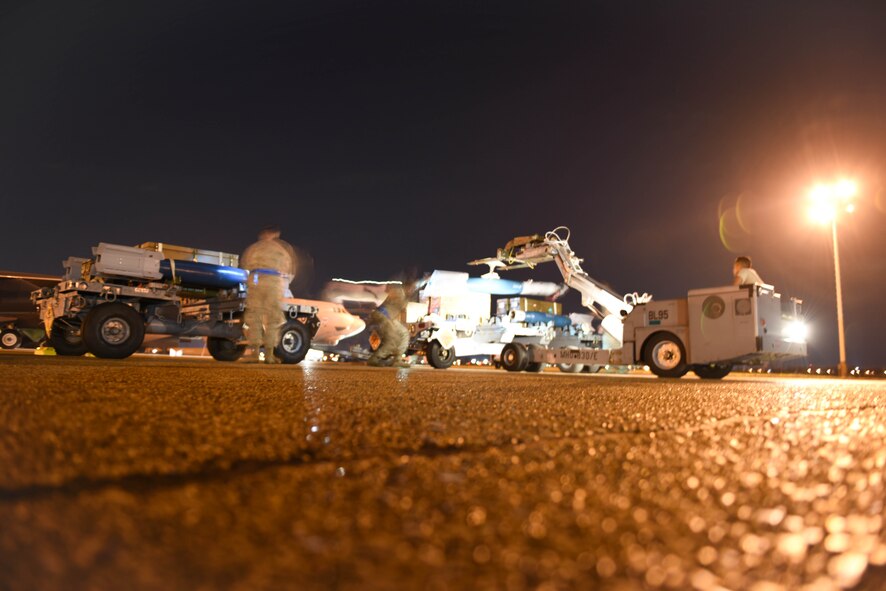 A weapons load crew begins the process of loading bombs onto a B-52 Stratofortress at Barksdale Air Force Base, La., Feb. 6, 2017. Combat Hammer is a way for the Air Force to evaluate munitions systems in their entirety and determine if there are any faults in them. (U.S. Air Force photo/Airman 1st Class Stuart Bright)