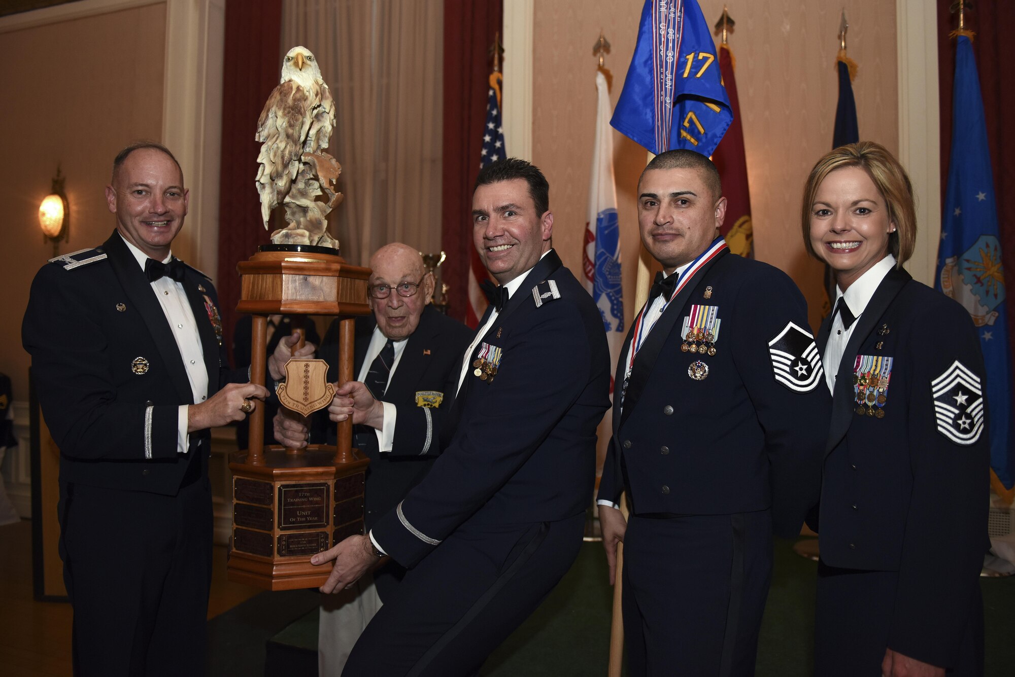 U.S. Air Force Col. Michael Down, 17th Training Wing Commander, and Retired Lt. Col. Dick Cole present the Unit of the Year award to Lt. Col. Achilles Hamilothoris, 17th Medical Support Squadron Commander at the Cactus Hotel in San Angelo, Texas, Feb. 3, 2017. Cole is the last remaining Doolittle Raider. (U.S. Air Force photo by Airman 1st Class Caelynn Ferguson/Released)
