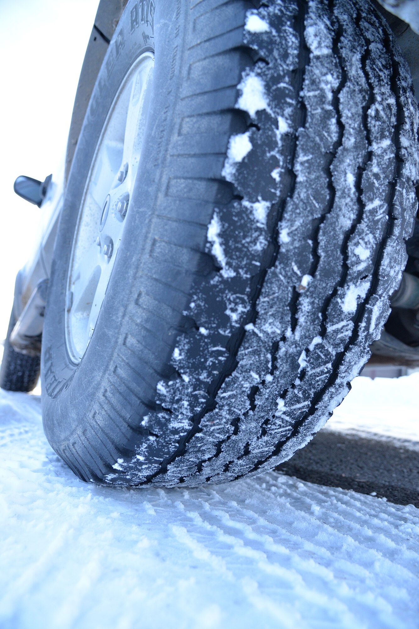 An icy vehicle tire is shown on top of a layer of ice during the winter months Feb. 8, 2017, at Malmstrom Air Force Base, Mont. To be safe driving during hazardous road conditions, the American Automobile Association suggests watching weather reports prior to leaving for a destination. AAA also suggests not using cruise control, increasing the normal dry pavement following distance from 3-4 seconds to 8-10 seconds, slowing down when visibility is low and accelerating and decelerating slowly. (U.S. Air Force photo/Airman 1st Class Daniel Brosam)