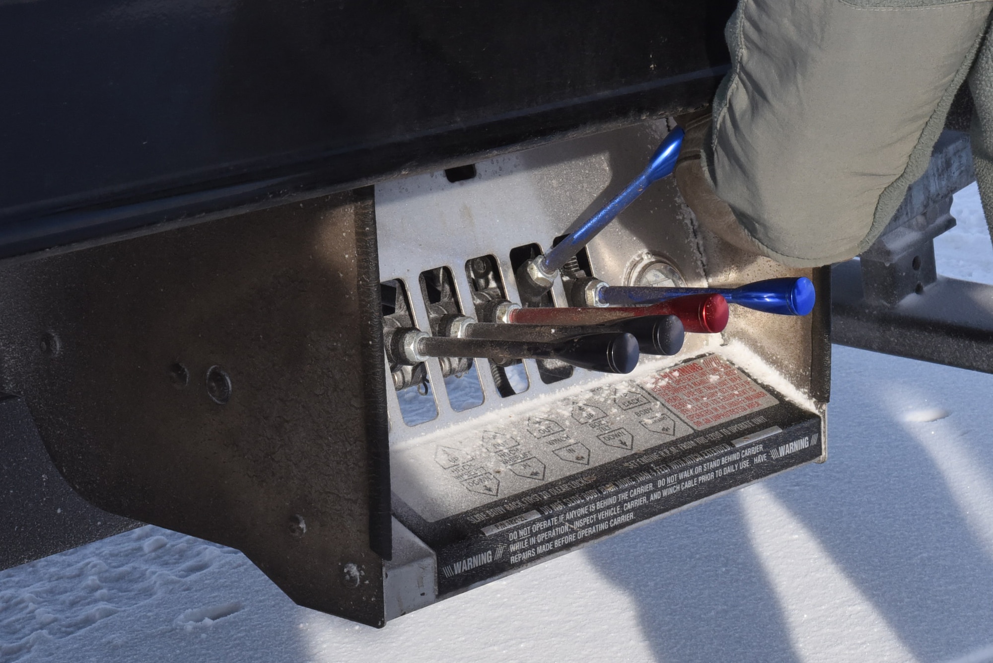 A 341st Logistics Readiness Squadron vehicle operator activates a ramp lowering on the flatbed of a tow truck as a Humvee is driven onto the truck at a missile alert facility and transferred to Malmstrom Air Force Base, Mont., for maintenance Feb. 7, 2017.  (U.S. Air Force photo/Jason Heavner) 