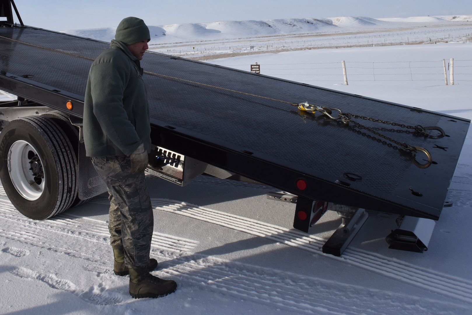 Senior Airman Leonard Montoya, 341st Logisitics Readiness Squadron vehicle operator, lowers the ramp to a tow truck as he prepares to move a Humvee onto the truck to be driven to Malmstrom Air Force Base, Mont., for maintenance Feb. 7, 2017.  (U.S. Air Force photo/Jason Heavner)