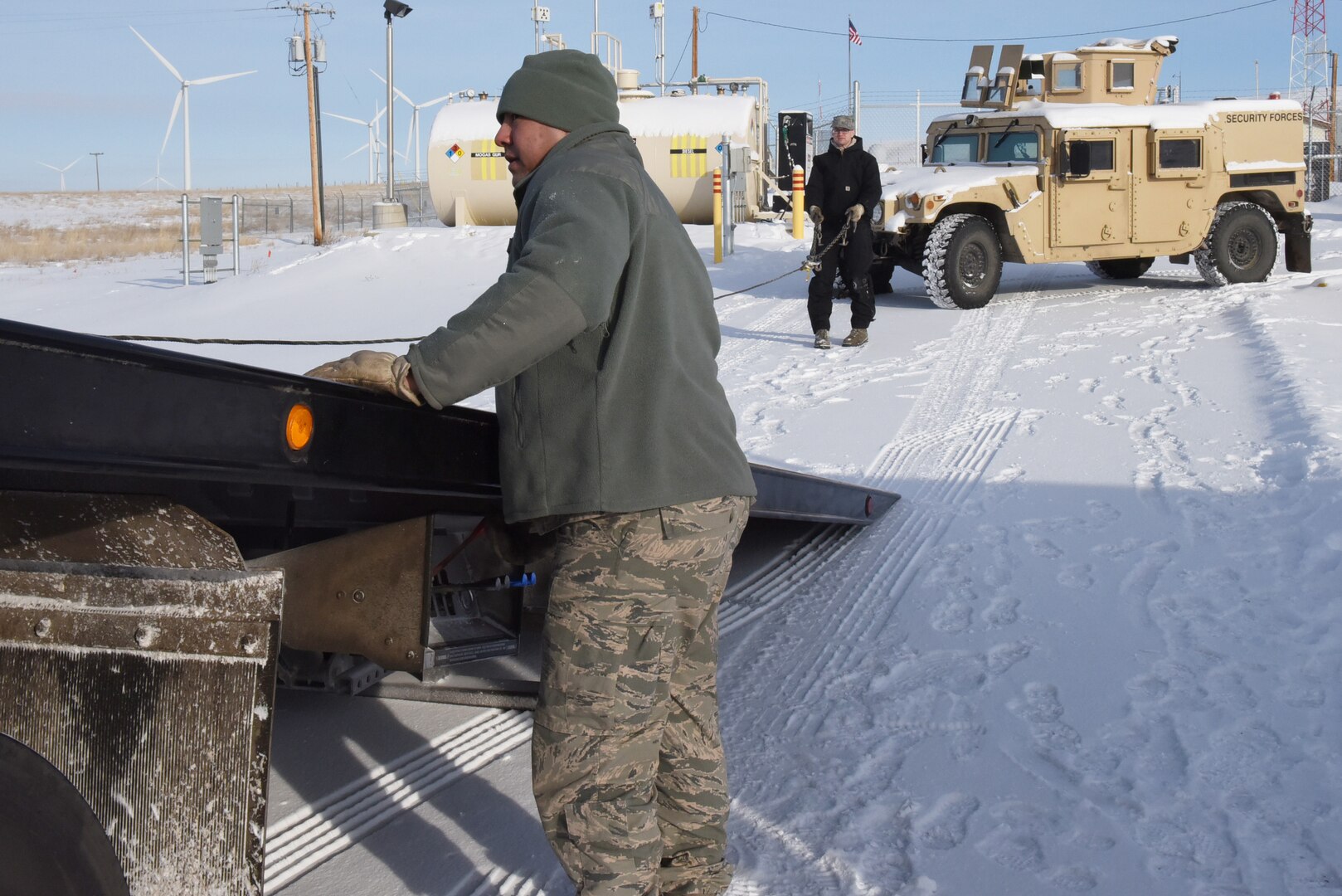 Senior Airmen Leonard Montoya, left, and Ian Lauzon, both 341st Logistics Readiness Squadron vehicle operators, prepare to move a Humvee onto the back of a tow truck at a missile alert facility which will later be transferred to Malmstrom Air Force Base, Mont., for maintenance Feb. 7,2017.  (U.S. Air Force photo/Jason Heavner)