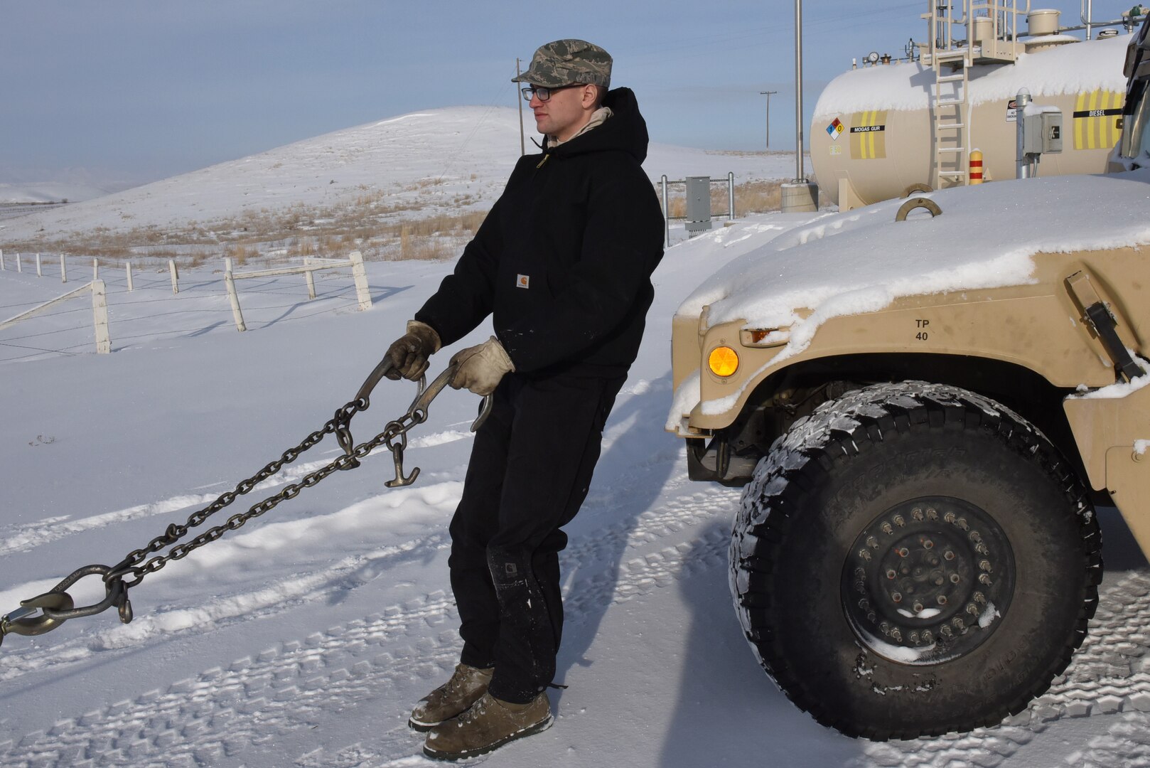 Senior Airman Ian Lauzon, 341st Logistics Readiness Squadron vehicle operator, prepares to connect towing cables to a Humvee at a missile alert facility Feb. 7, 2017.  The Humvee will be towed to Malmstrom Air Force Base, Mont., for maintenance.  (U.S. Air Force photo/Jason Heavner)           