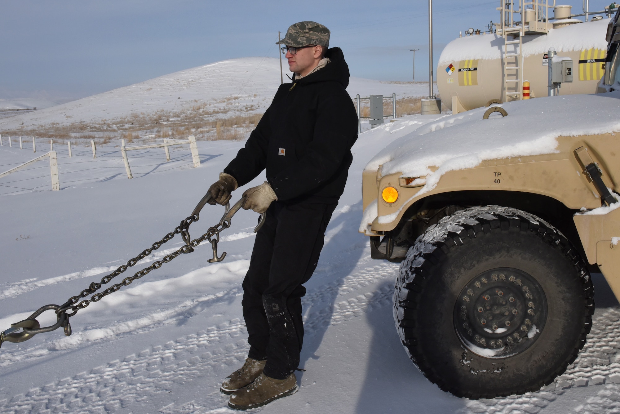 Senior Airman Ian Lauzon, 341st Logistics Readiness Squadron vehicle operator, prepares to connect towing cables to a Humvee at a missile alert facility Feb. 7, 2017.  The Humvee will be towed to Malmstrom Air Force Base, Mont., for maintenance.  (U.S. Air Force photo/Jason Heavner)           