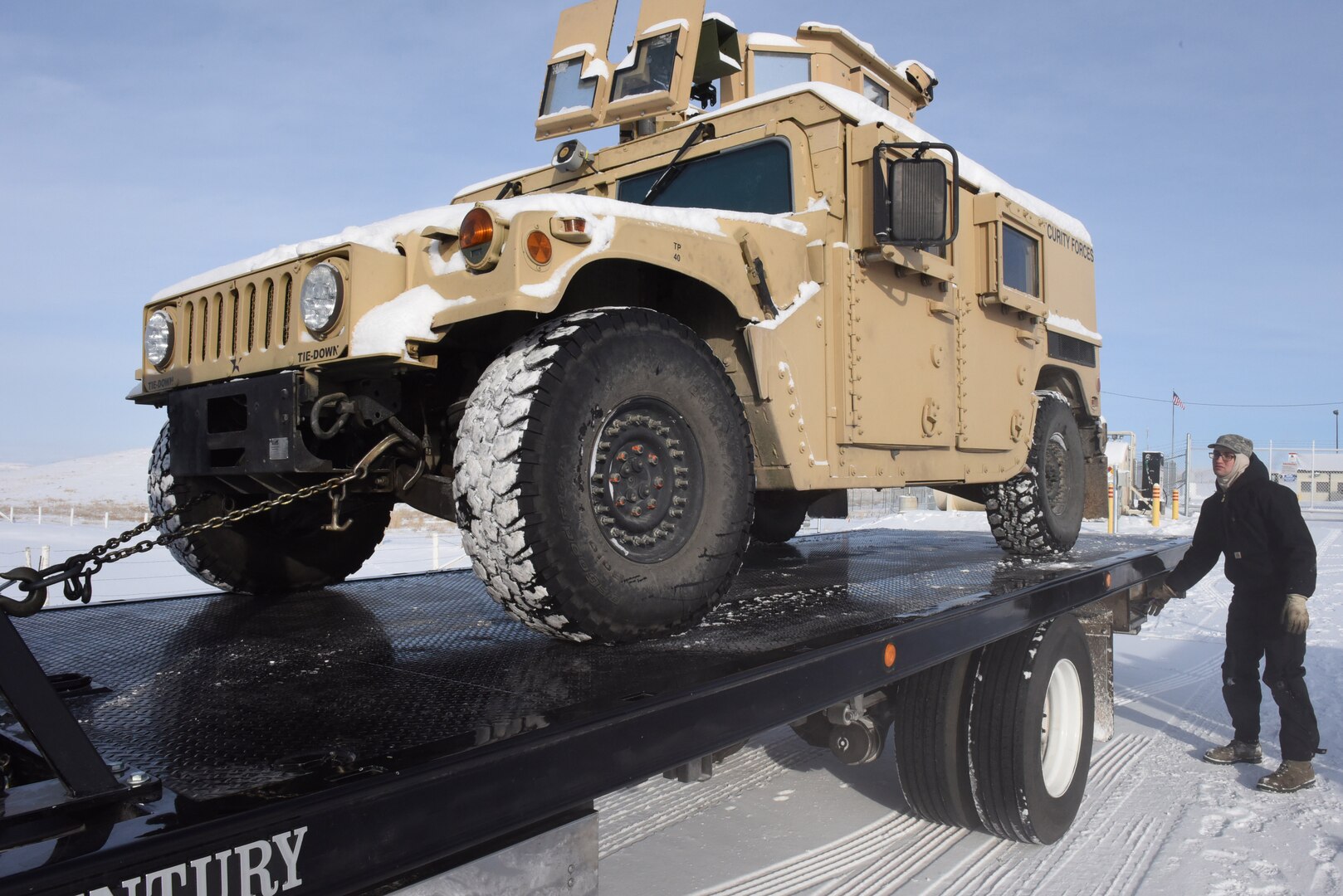 Senior Airman Ian Lauzon, 341st Logistics Readiness Squadron vehicle operator, adjusts the ramp of a tow truck in preparation for transferring a Humvee to Malmstrom Air Force Base, Mont., for maintenance Feb. 7, 2017.  In addition to vehicles needing repair, the 341 LRS vehicle operators maintain a fleet of more than 800 government vehicles that travel both on base and in the nearly 13,800 square mile missile field located in central Montana.  (U.S. Air Force photo/Jason Heavner)