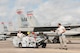 Staff Sgt. Timothy Mannion, the Three Man on the load crew, drives the jammer while Tech. Sgt. Lucas Hagopian, Weapons Load Crew Chief, oversees the load crew arming the 104th Fighter Wing's F-15 Eagle operations at the U.S. Air Force's Weapons System Evaluation Program at Tyndall, Air Force Base. The purpose of WSEP is to gauge operational effectiveness, to verify weapons system performance, determine reliability, and evaluate capability. (U.S. Air National Guard Photo by Senior Master Sgt. Julie Avey)